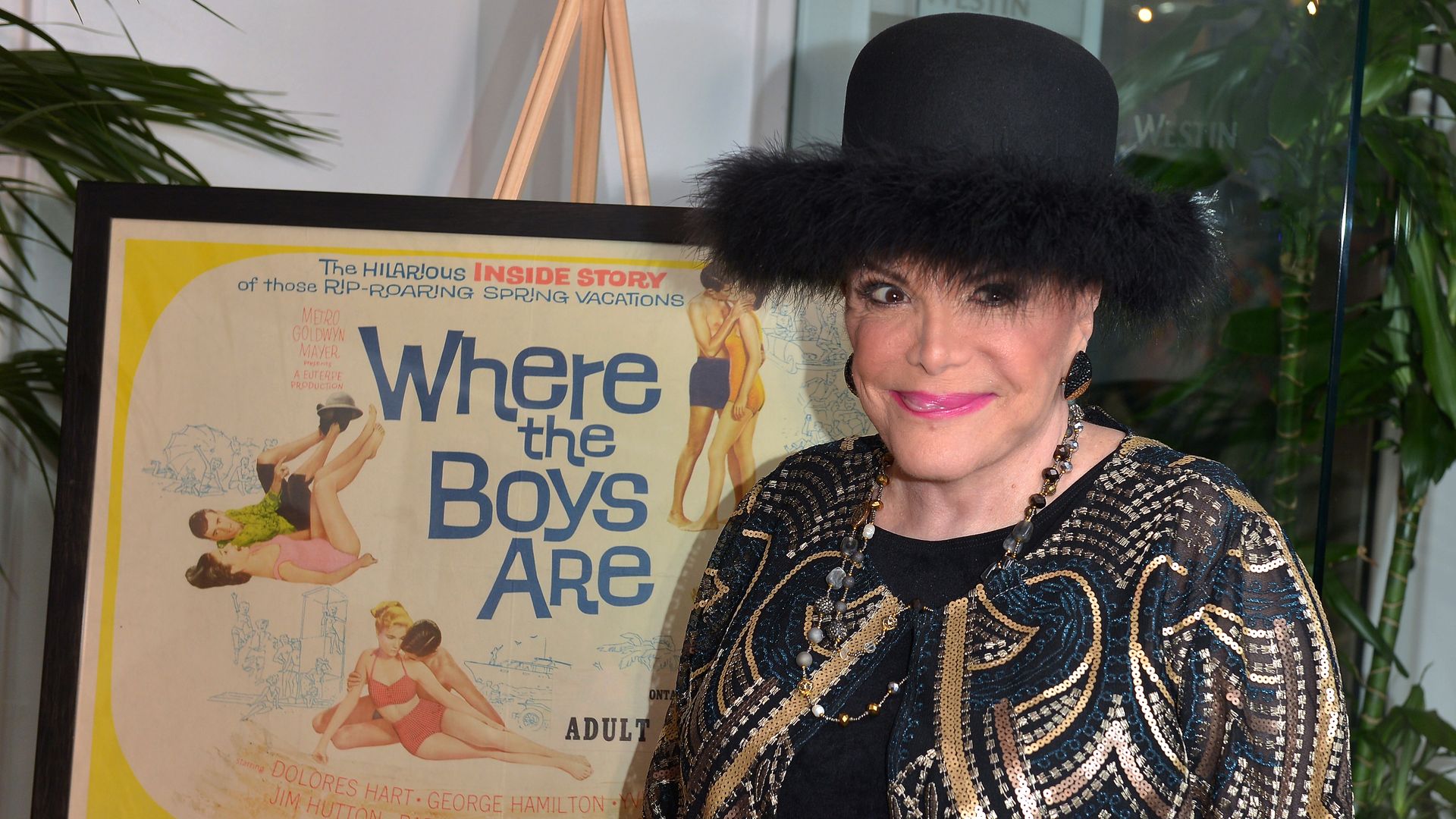 Connie Francis posing next to a movie poster. 