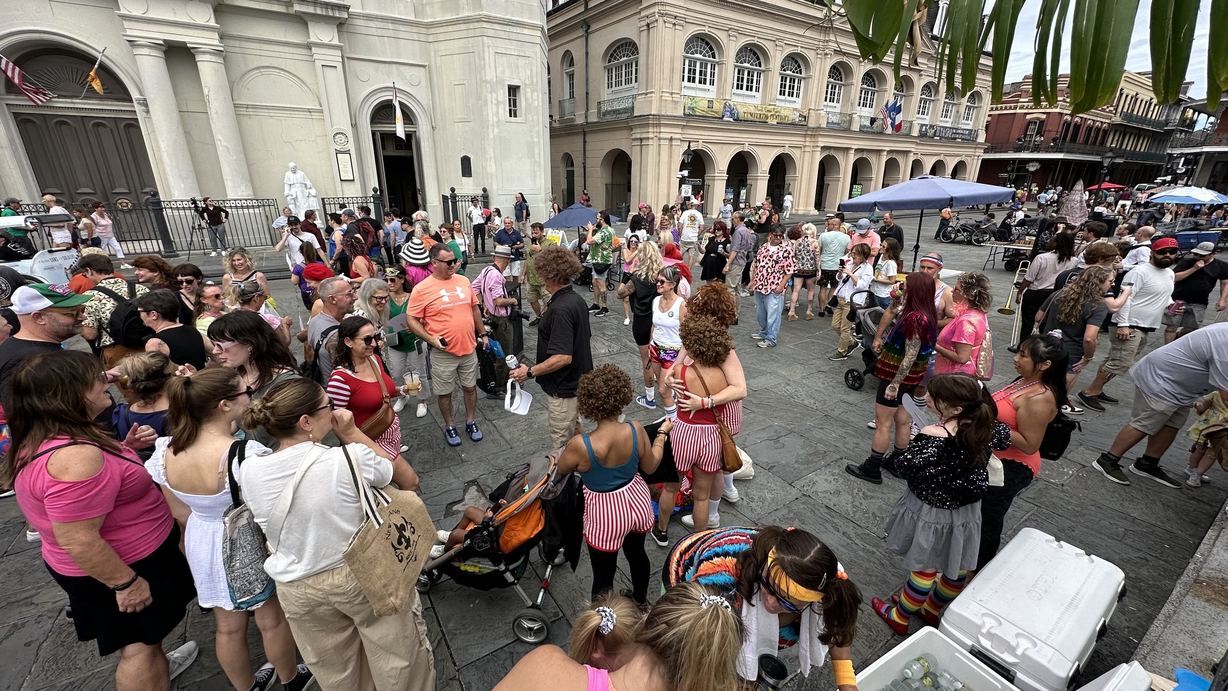 As a crowd gathers, two people hug in front of the St. Louis Cathedral.