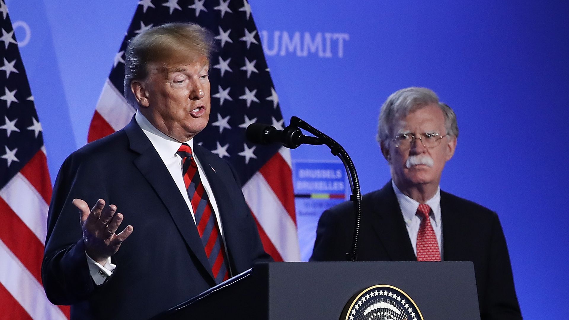 President Trump speaks as John Bolton looks on.