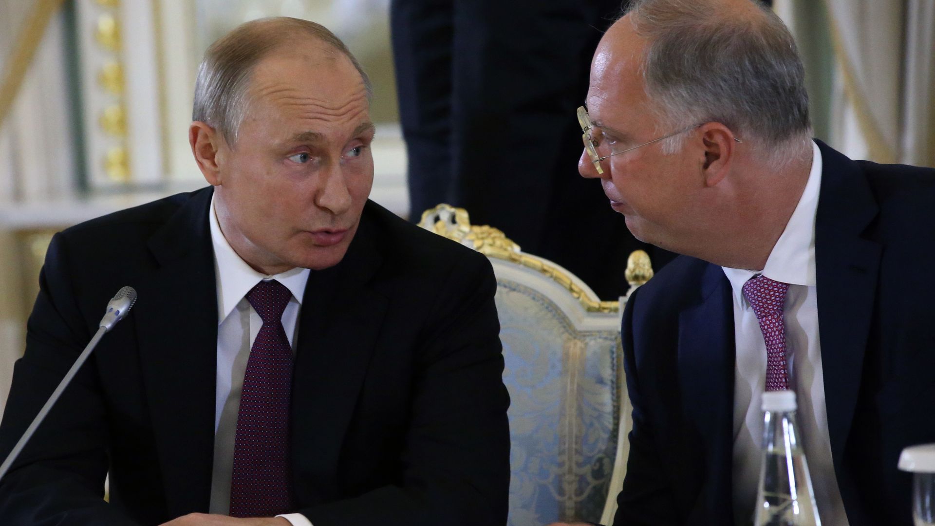 Two balding white men talking