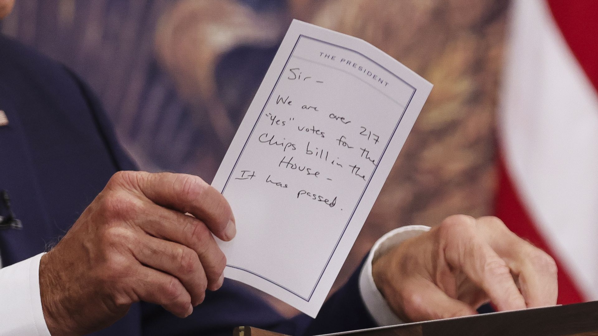 Biden holds note that says CHIPS bill has passed