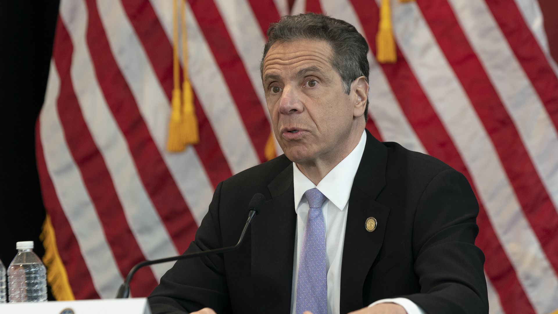 In this image, Andrew Cuomo sits and talks