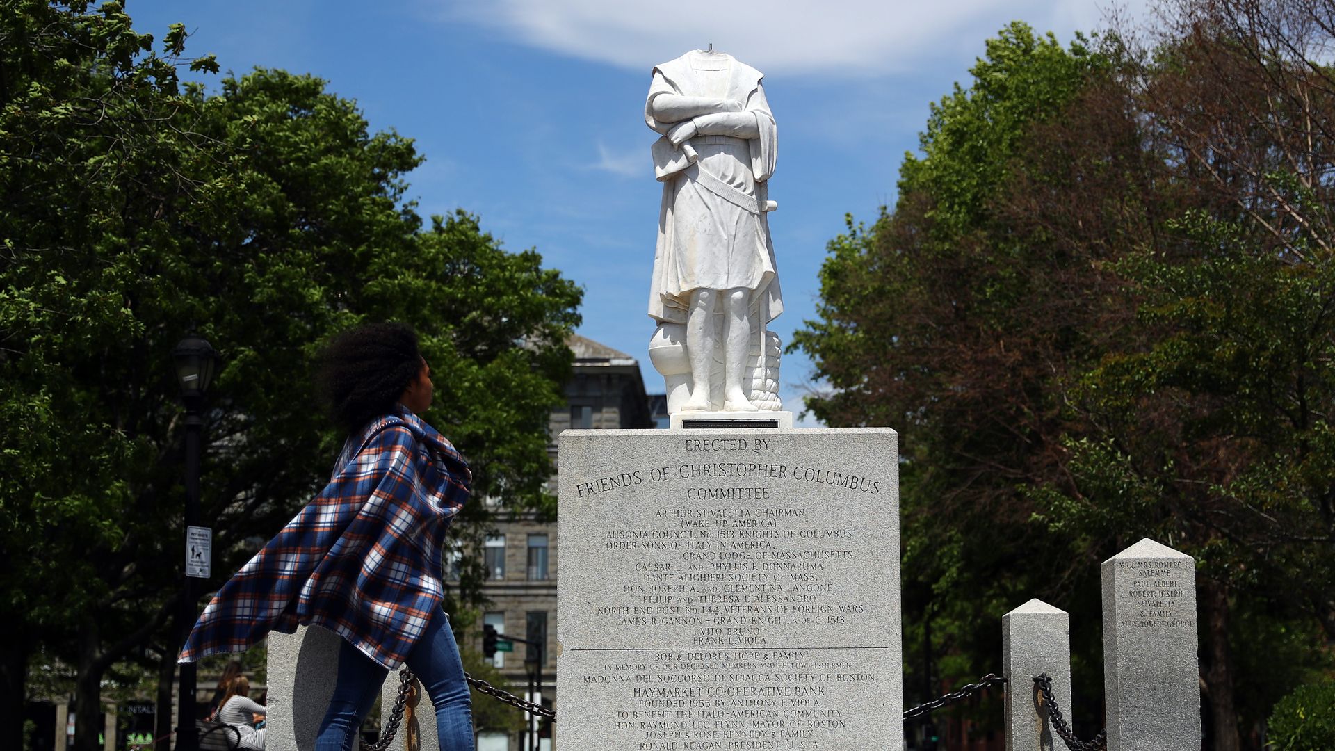 BOSTON, MASSACHUSETTS - JUNE 10: A woman looks at a statue depicting Christopher Columbus which had its head removed at Christopher Columbus Waterfront Park on June 10, 2020 in Boston, Massachusetts. The statue was beheaded overnight and is scheduled to be removed by the City of Boston. (Photo by Ti