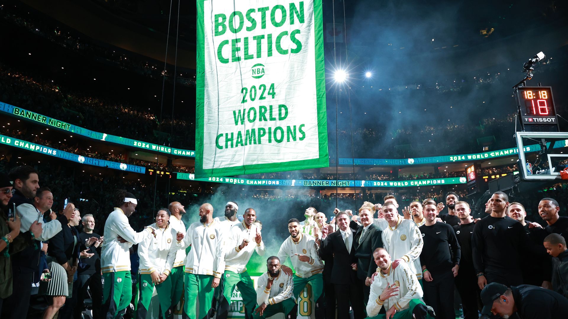 Celtics players pose for a photo while the 2024 championship banner gets raised before the game against the New York Knicks on October 22, 2024 at TD Garden in Boston. 