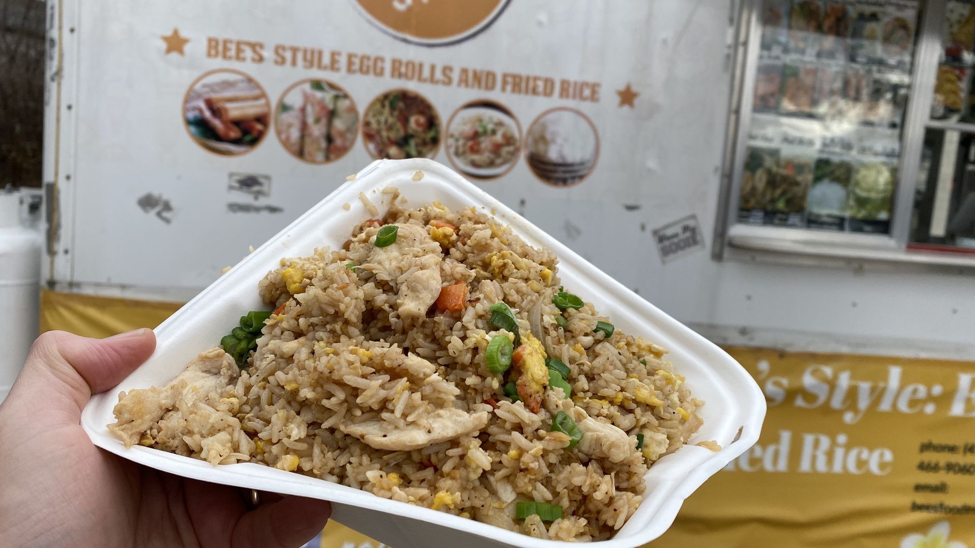 An order of chicken fried rice held up in front of a food truck