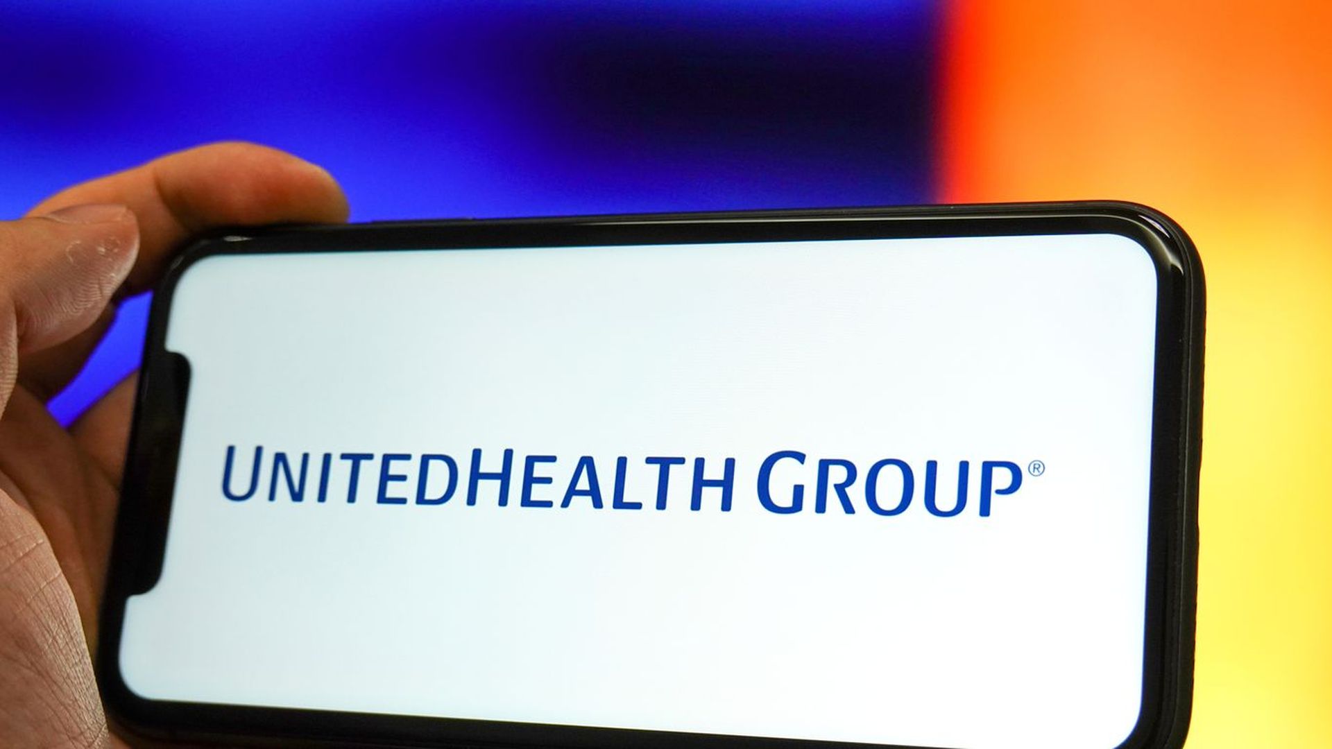 Photo illustraiton of UnitedHealth Group logo on a smartphone screen.