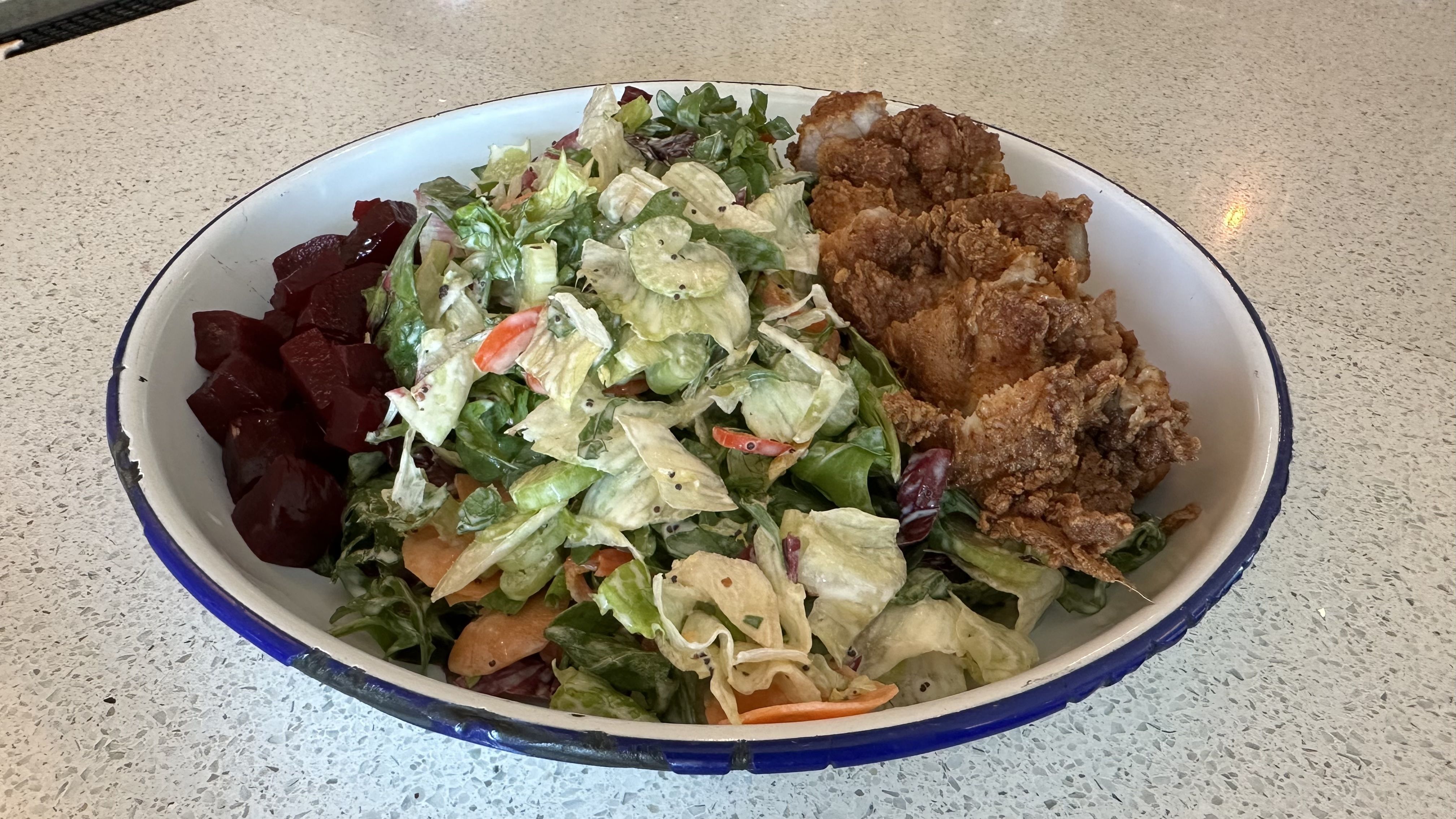 A photo of a salad on a countertop.