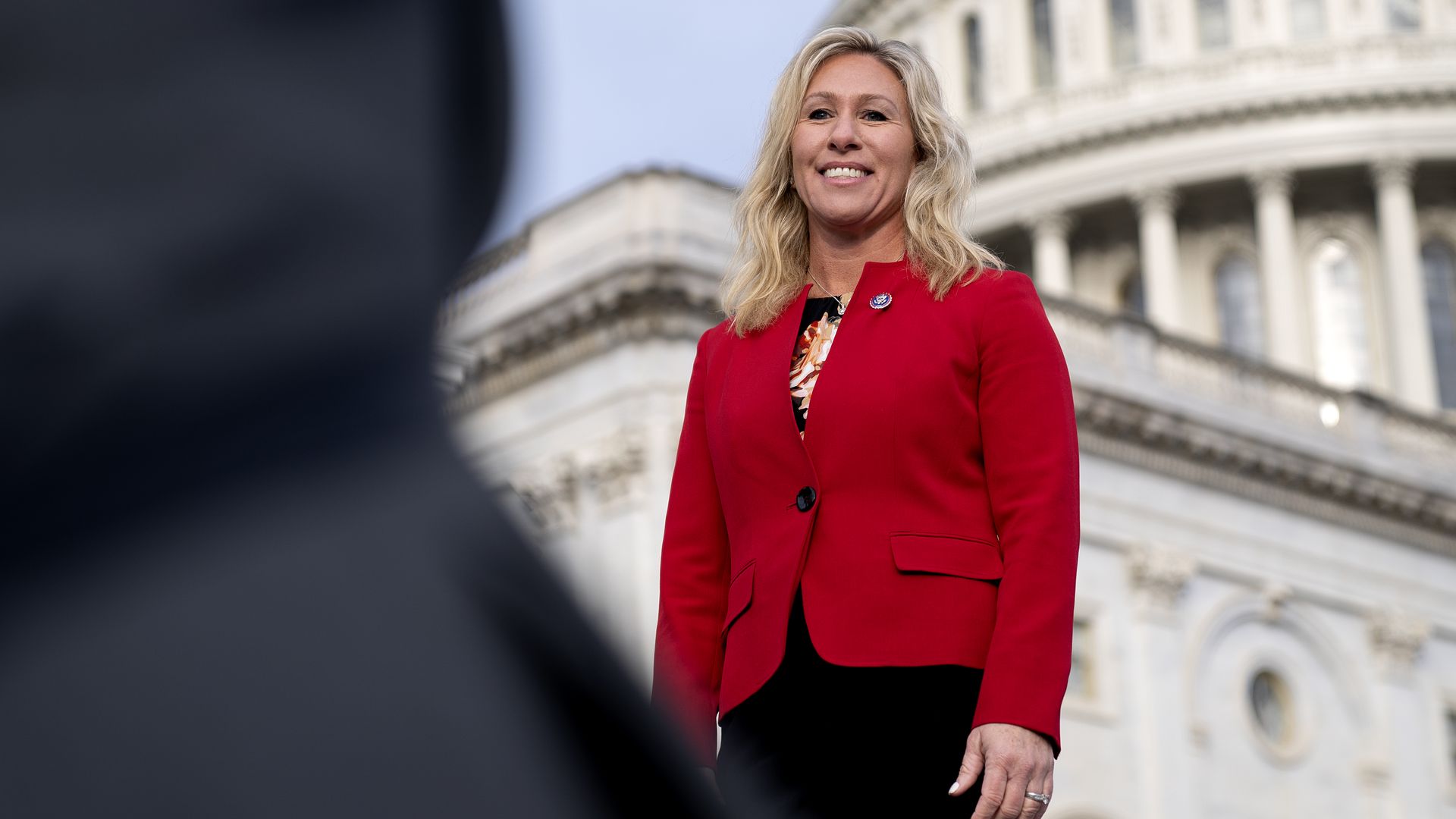 Rep. Marjorie Taylor Greene is seen posing for a photo in front of the U.S. Capitol.