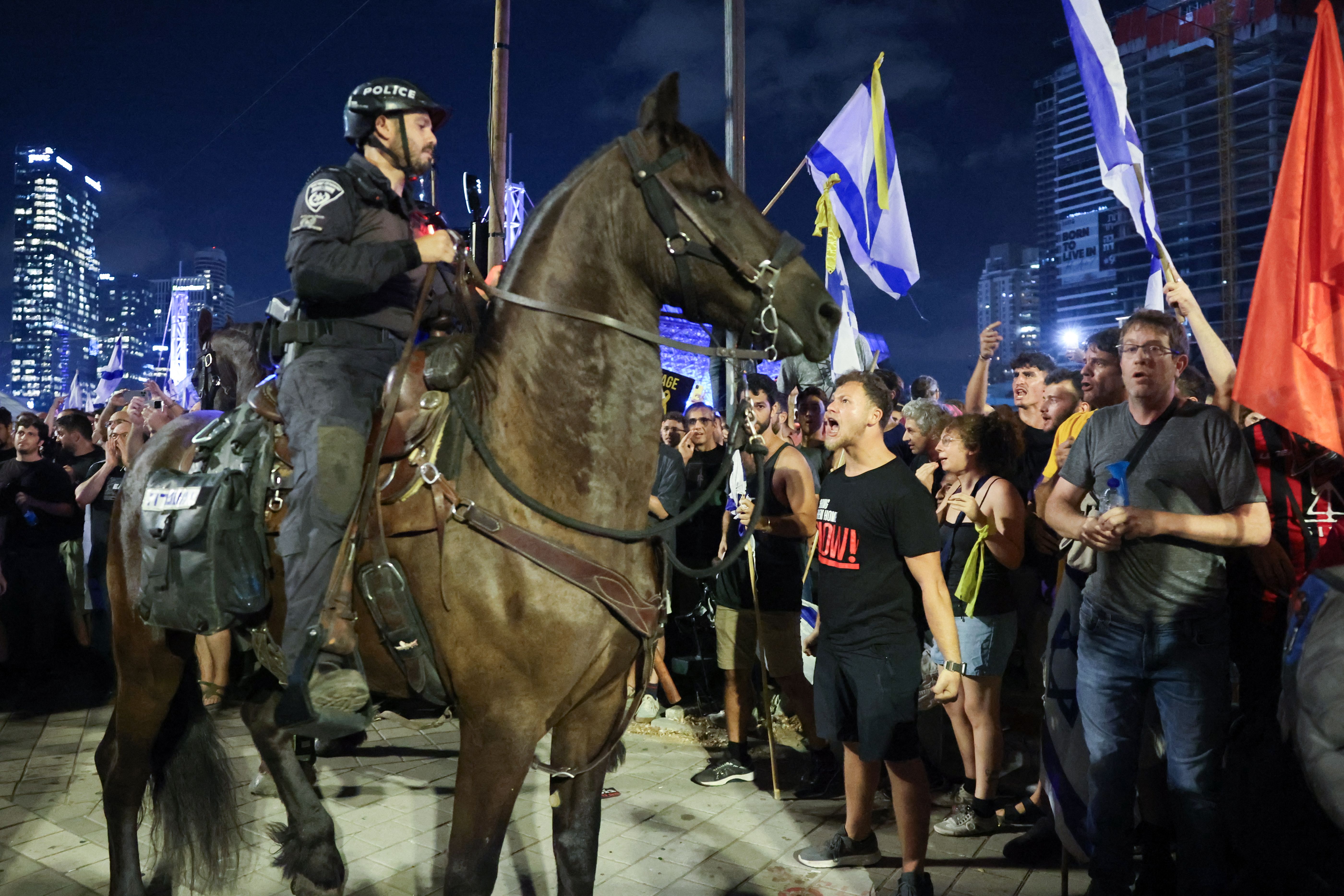 Protesters face Israeli Equestrian Police officers during an anti-government rally calling for the release of Israelis held hostage by Palestinian militants in Gaza since October, in Tel Aviv on September 1, 2024.