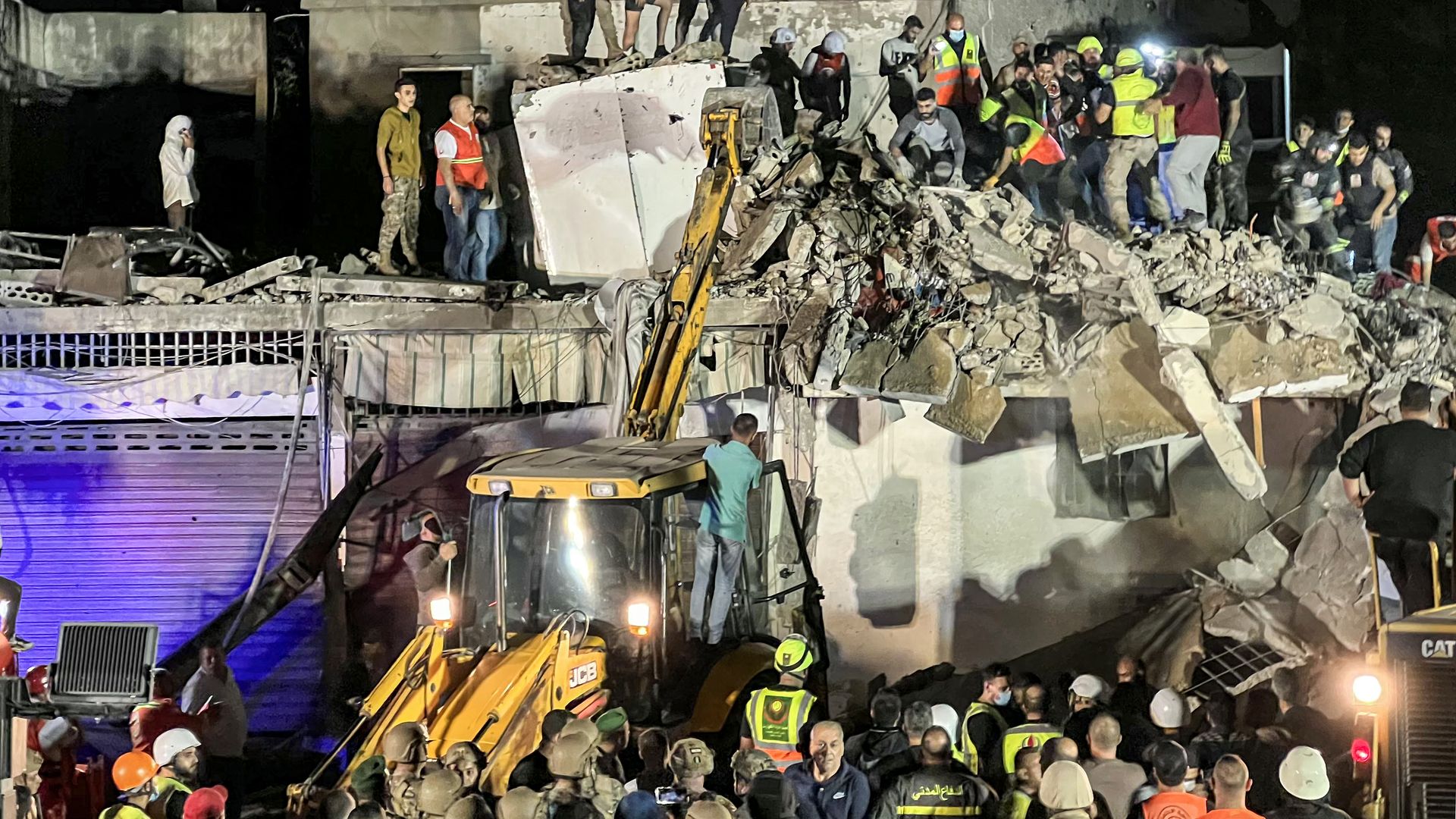 Civil defence rescuers search for survivors at the site of an Israeli air strike on the village of Haret Saida, near Lebanon's southern city of Sidon, on October 29, 2024.