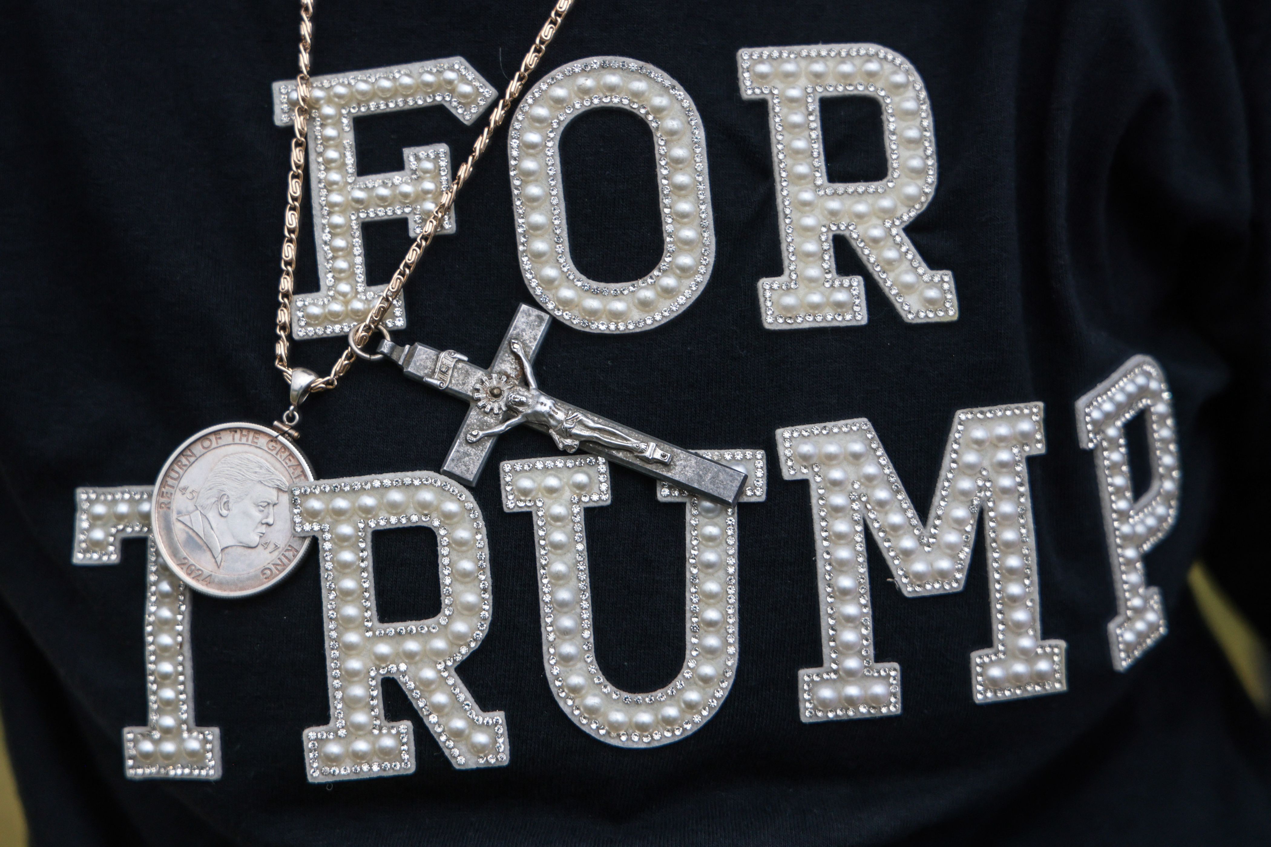 A close up image of a person's shirt that reads FOR TRUMP in bedazzeled type. 