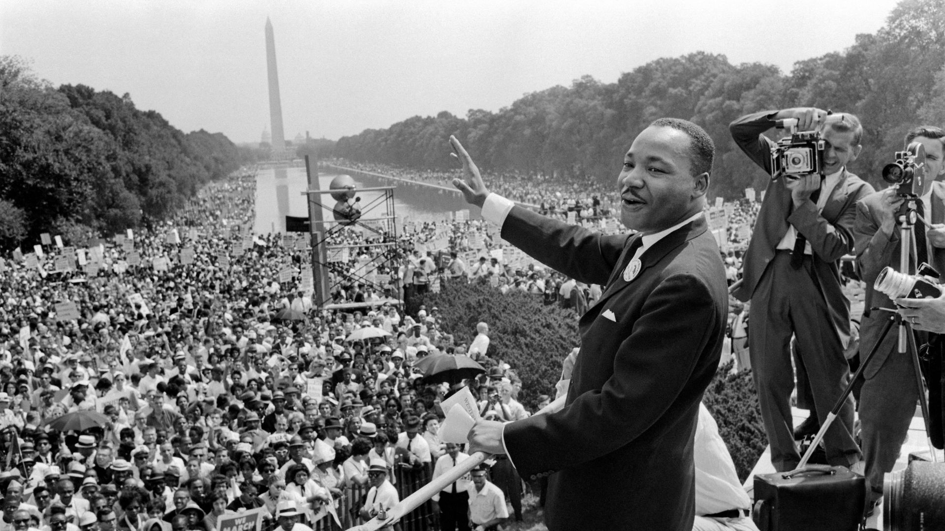 Martin Luther King (C) waves to supporters 28 August 1963 on the Mall in Washington DC (Washington Monument in background) during the "March on Washington", where King delivered his famous "I Have a Dream" speech.