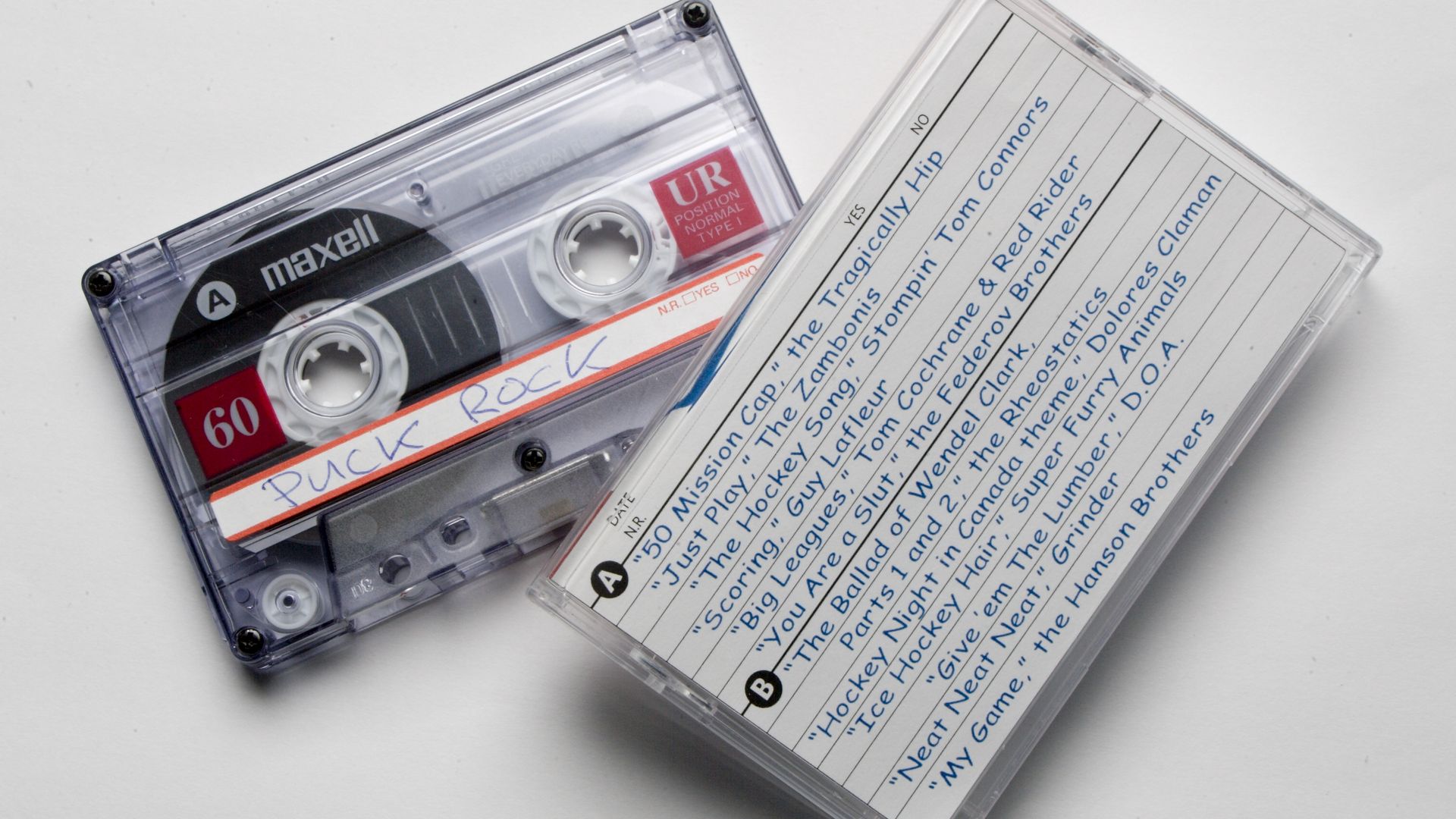An audio cassette tape alongside its case