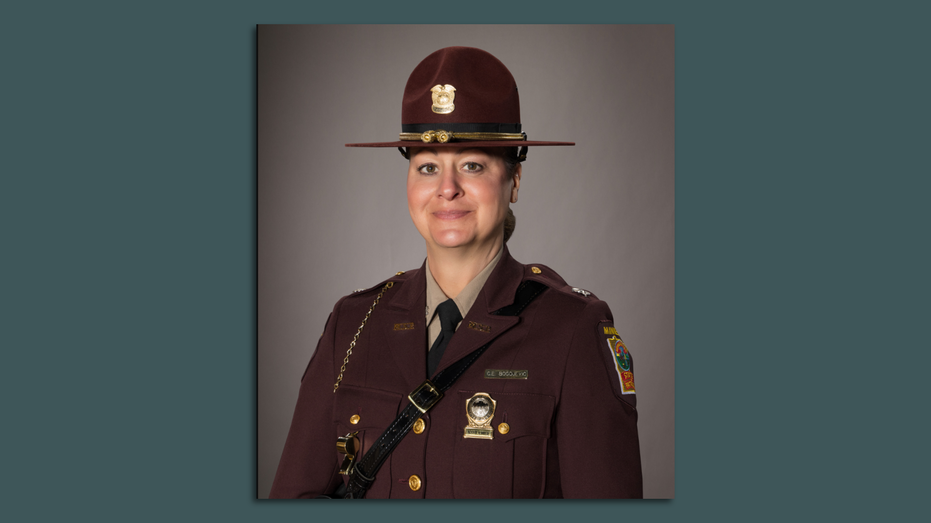 A woman in a brown state patrol jacket and hat