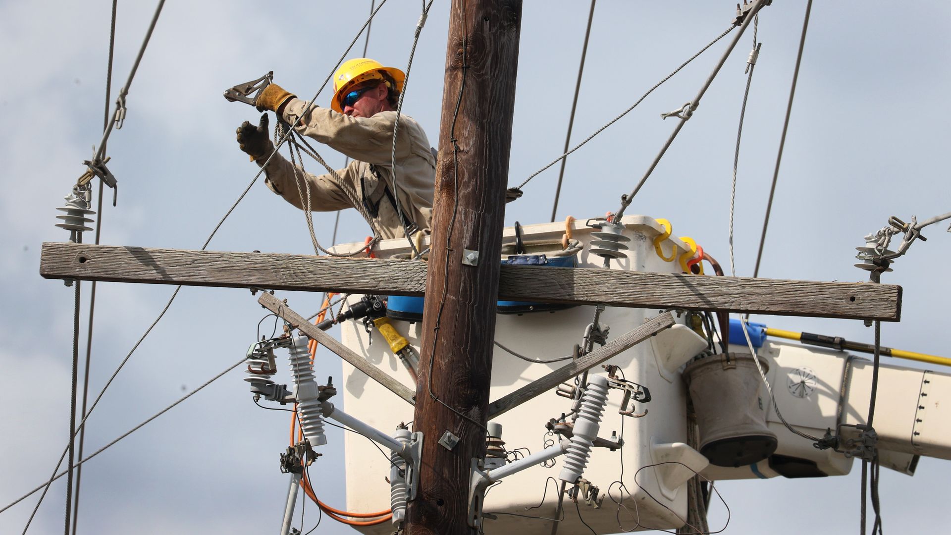 Workers repair power lines damaged by Hurricane Ida on August 31, 2021 in Houma, Louisiana