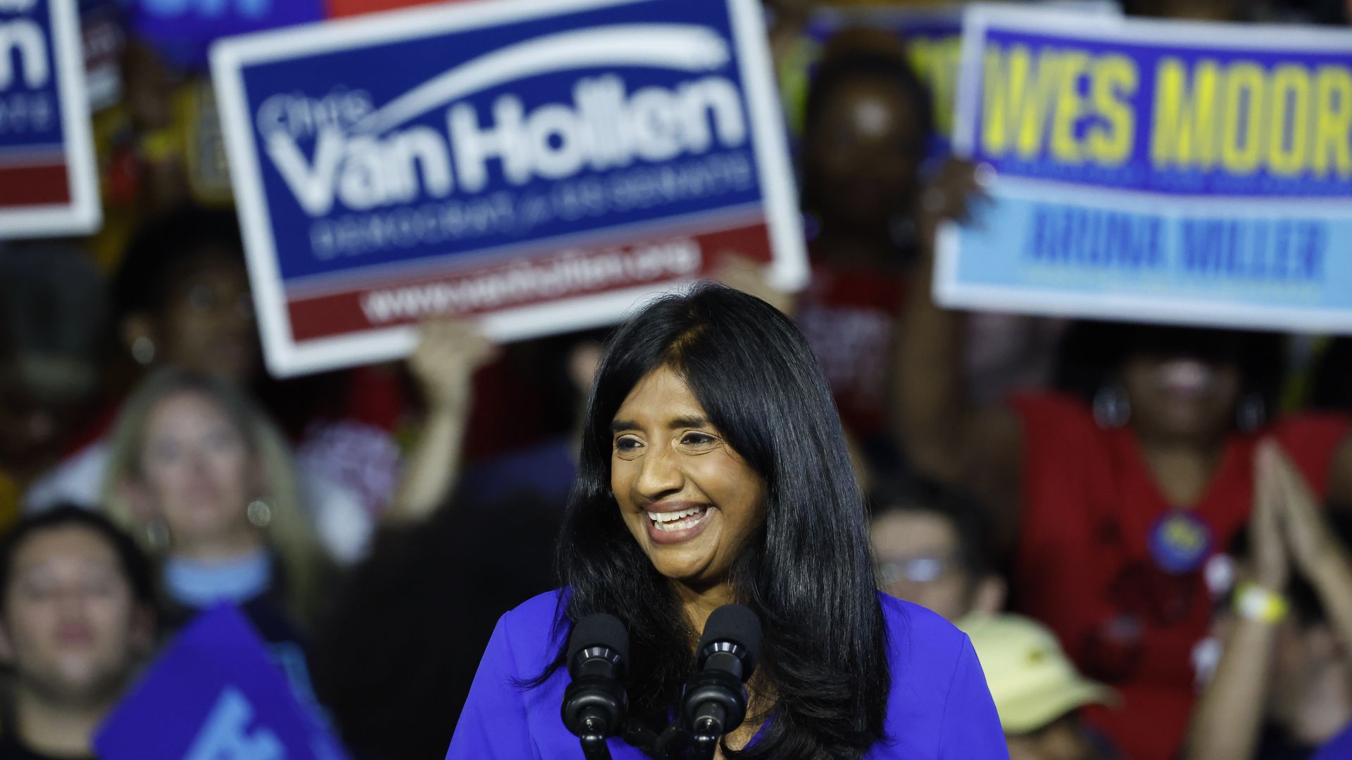 Photo of Aruna Miller smiling while speaking from a podium at a campaign rally