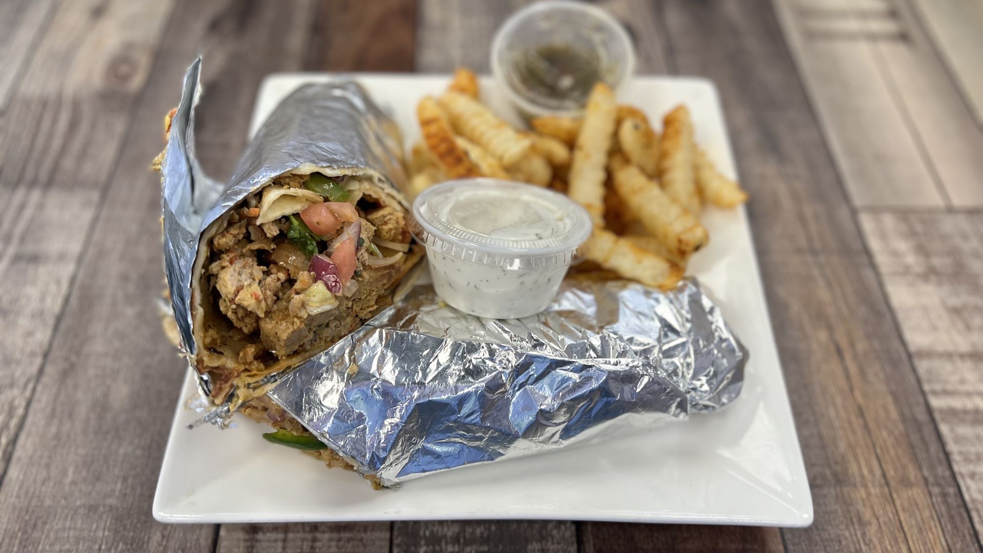A delicious looking chicken wrap and fries