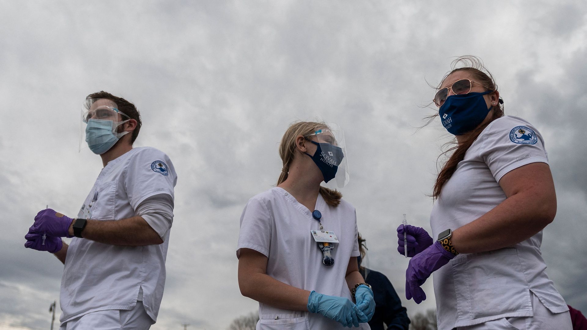 Three people standing next to each other with protective gear on 