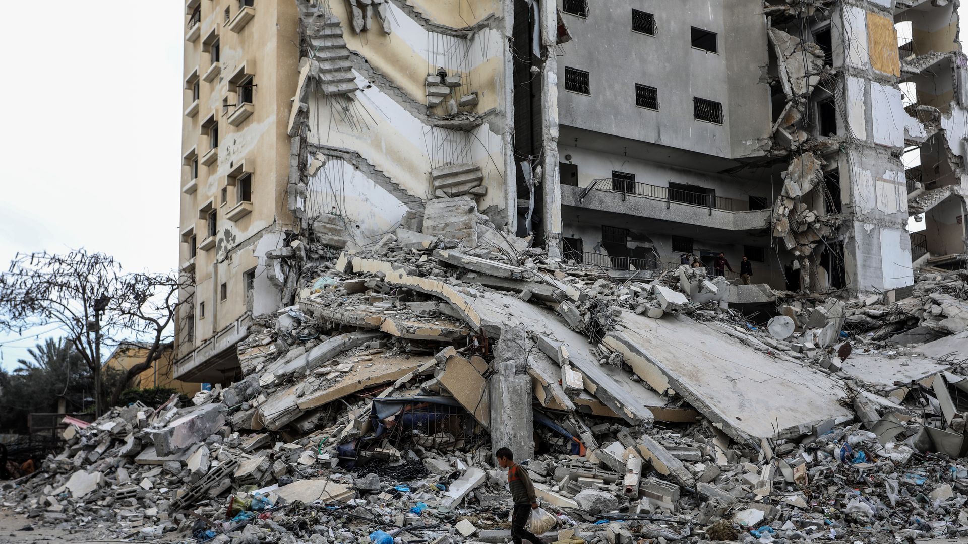 People pass by the damaged Burj al-Masri building and the surroundings after Israeli attacks in Rafah City of Gaza on March 18, 2024. (Photo by Abed Rahim Khatib/Anadolu via Getty Images)