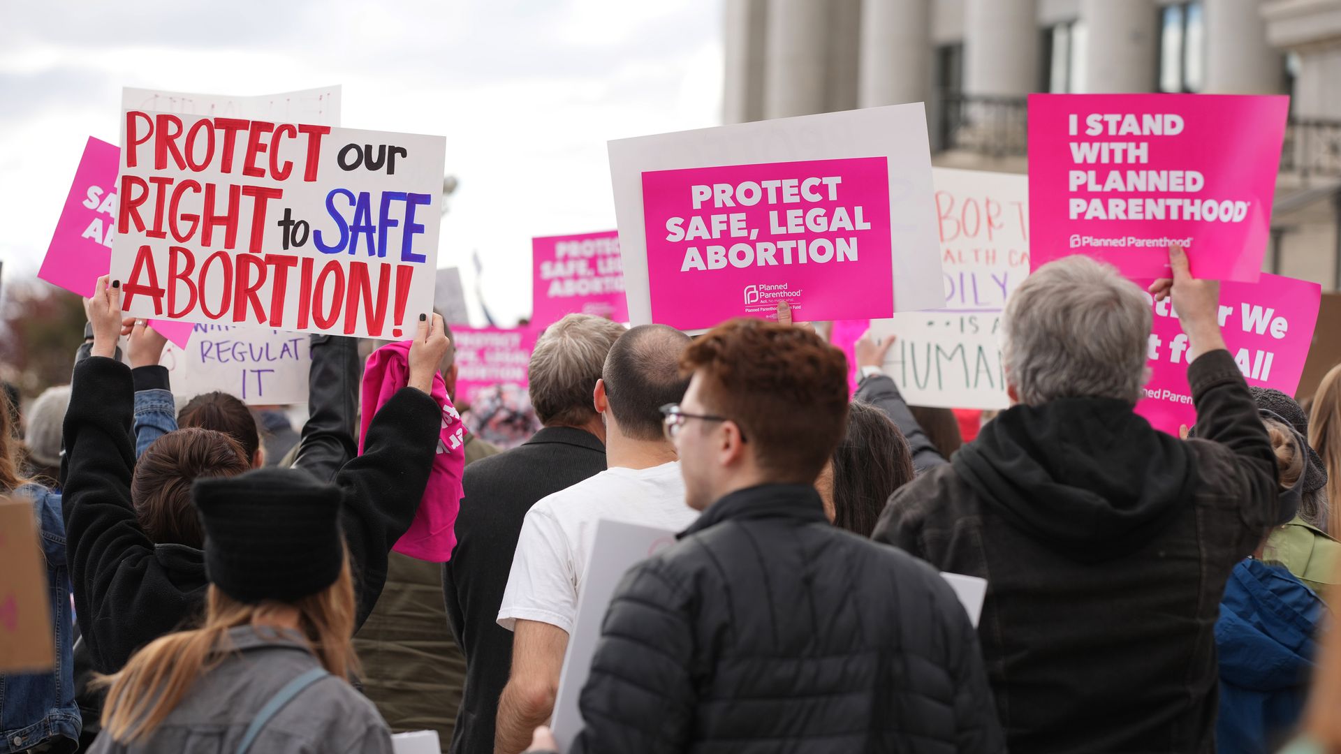 Signs at a rally read "Protect our right to safe abortion" and "Protect safe, legal abortion." 