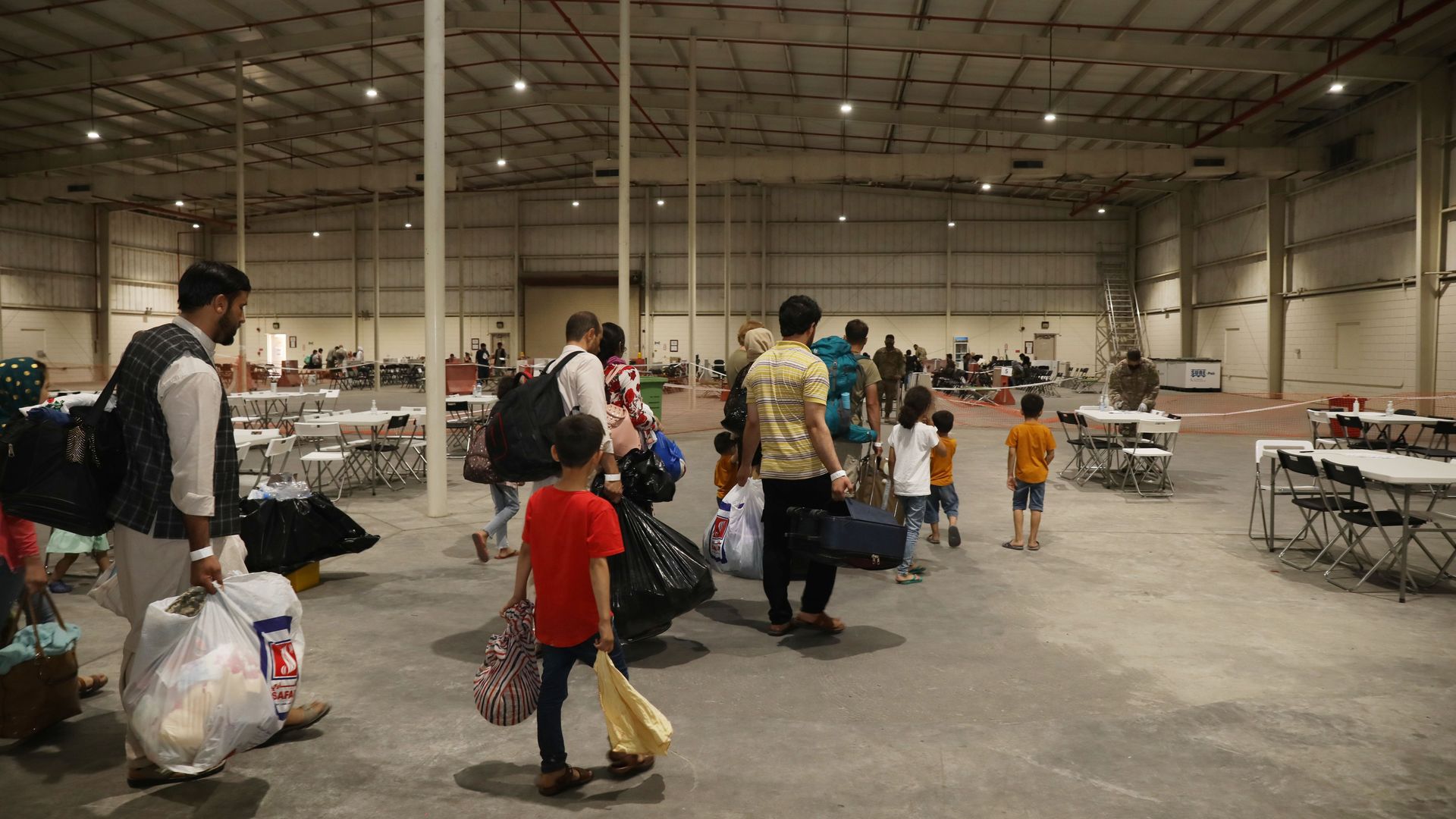 Afghan refugees are seen walking through a processing center in Qatar.