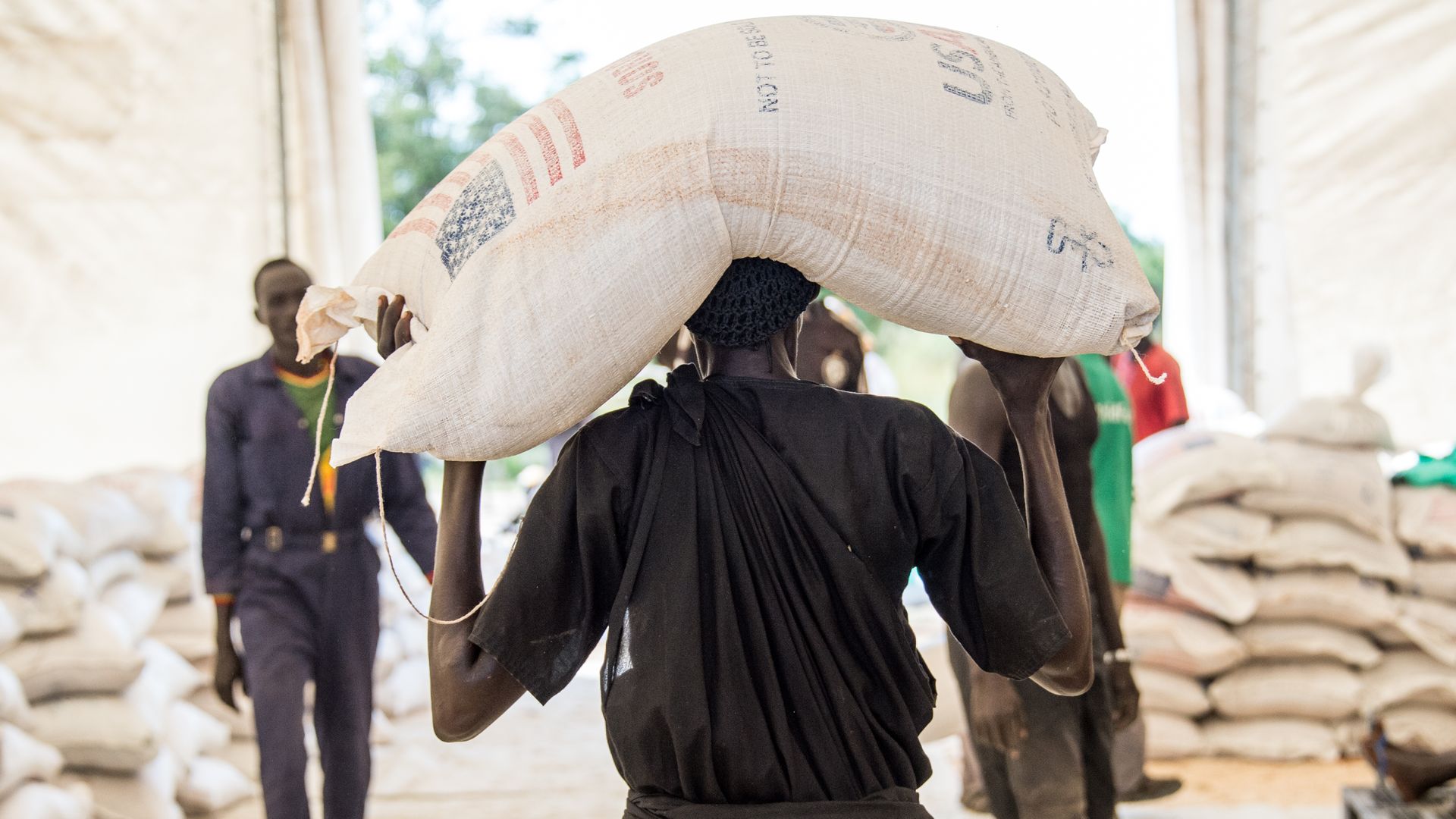 A person carries a USAID food supply bag in South Sudan.