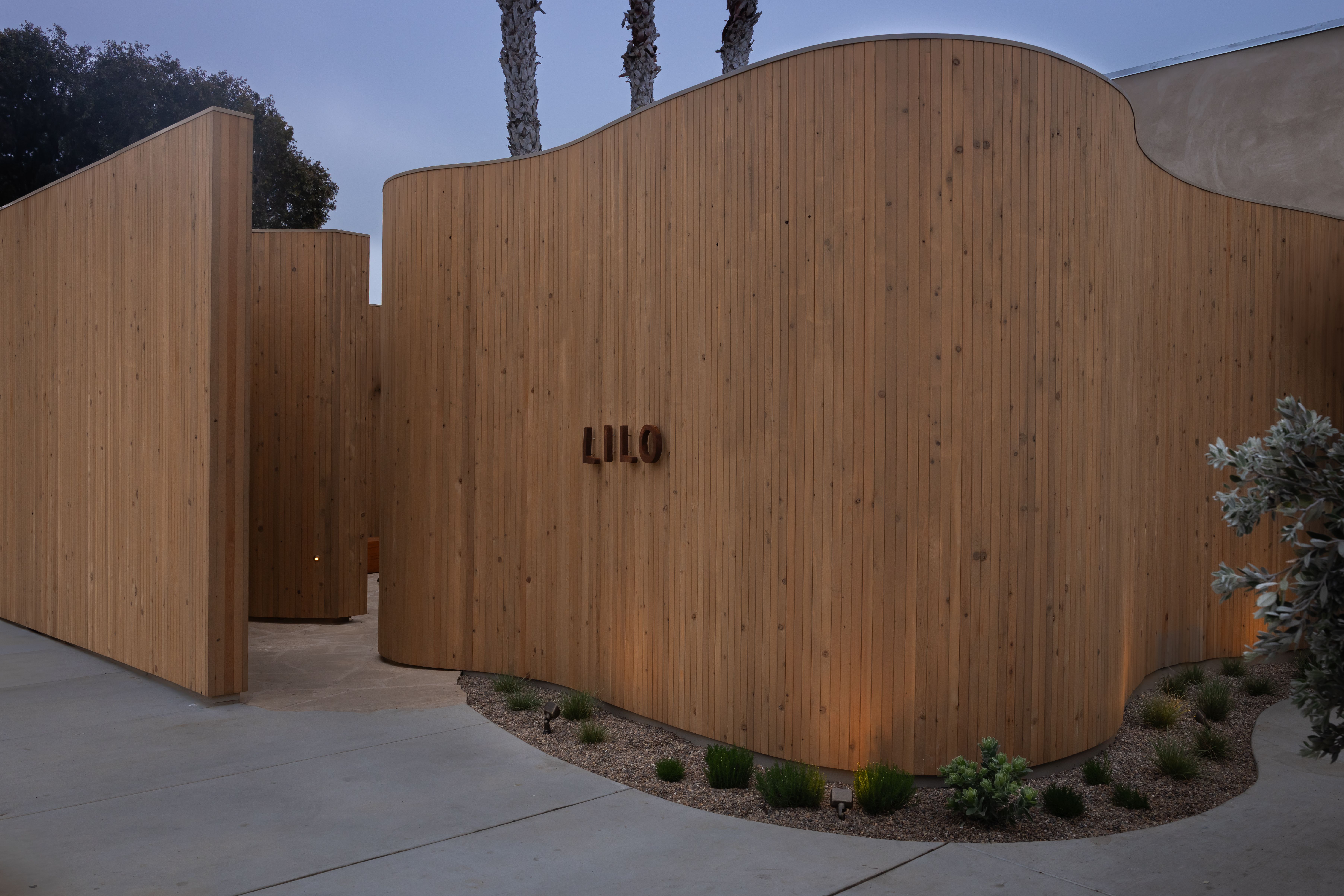 Curved, wood-paneled walls outside mark the entrance at Lilo. 
