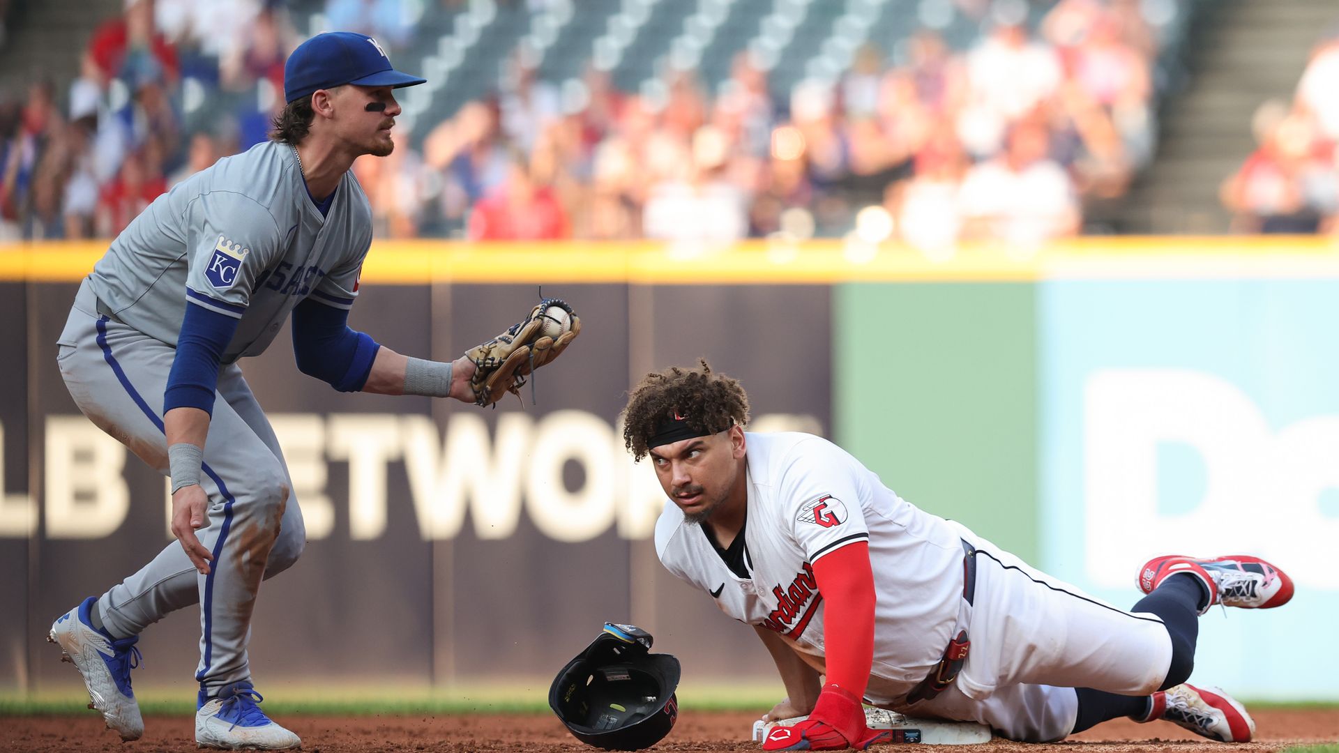 A Guardians player slides into second base after a Royals player tags him out.
