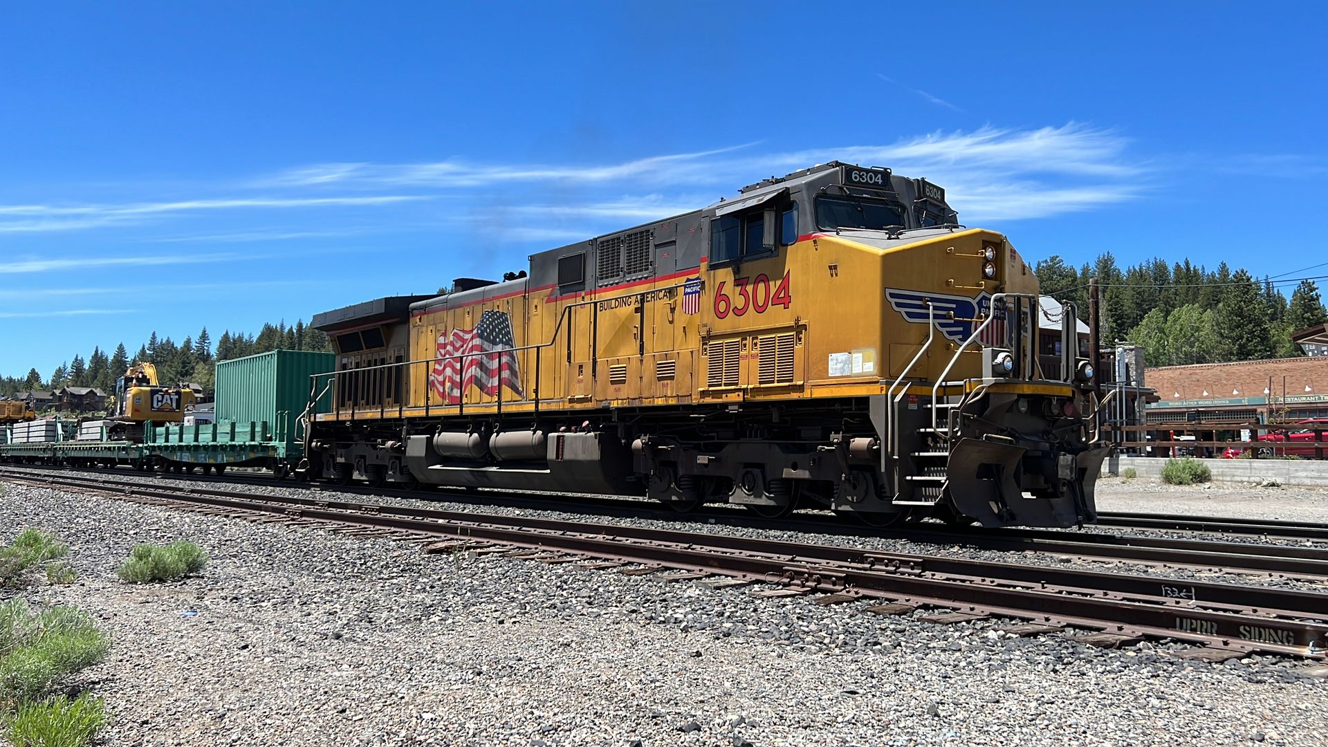 A Union Pacific locomotive pulling railcars is visible on tracks in Truckee, California.