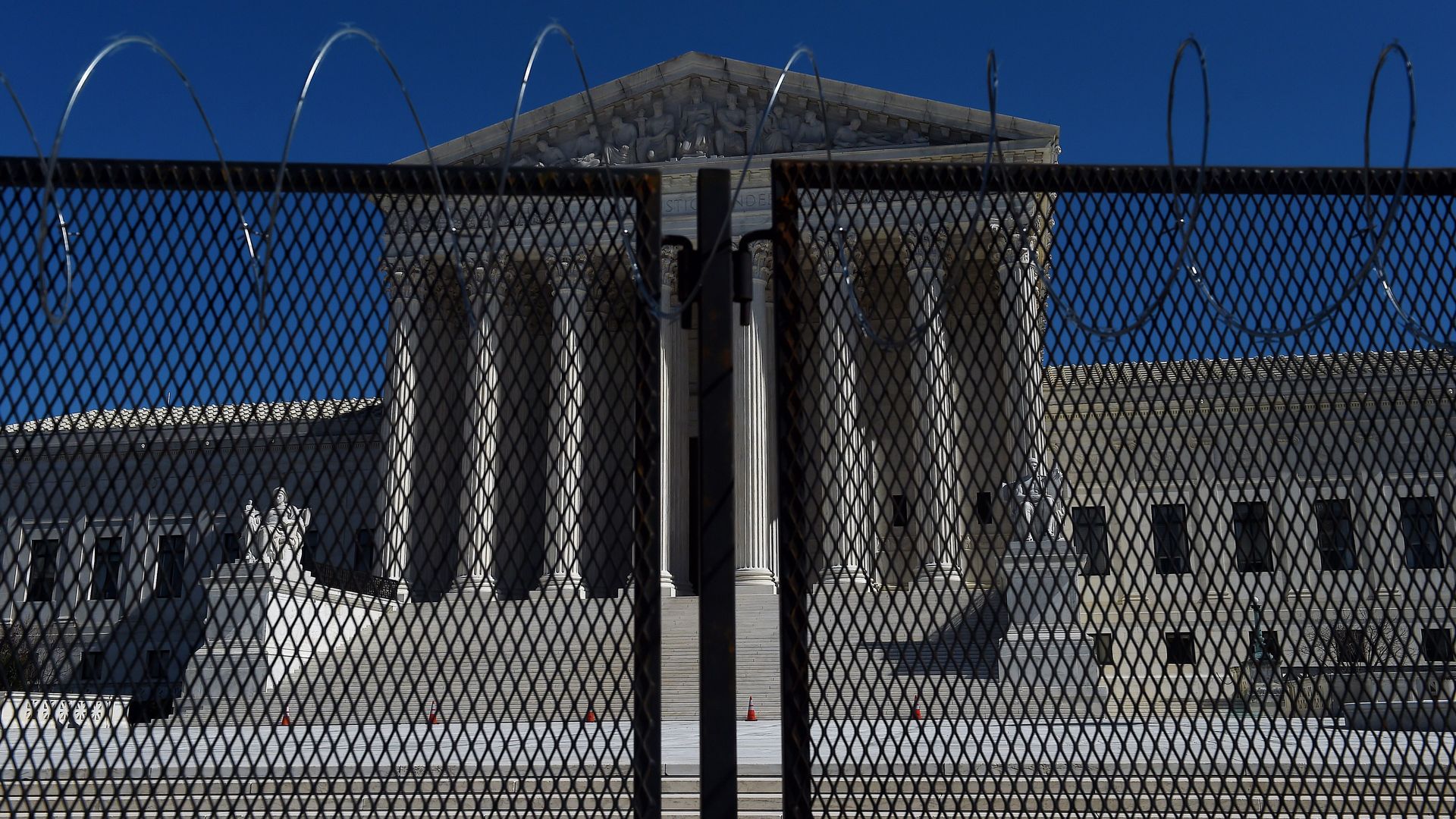 Supreme Court is seen through a fence topped with barbed wire 