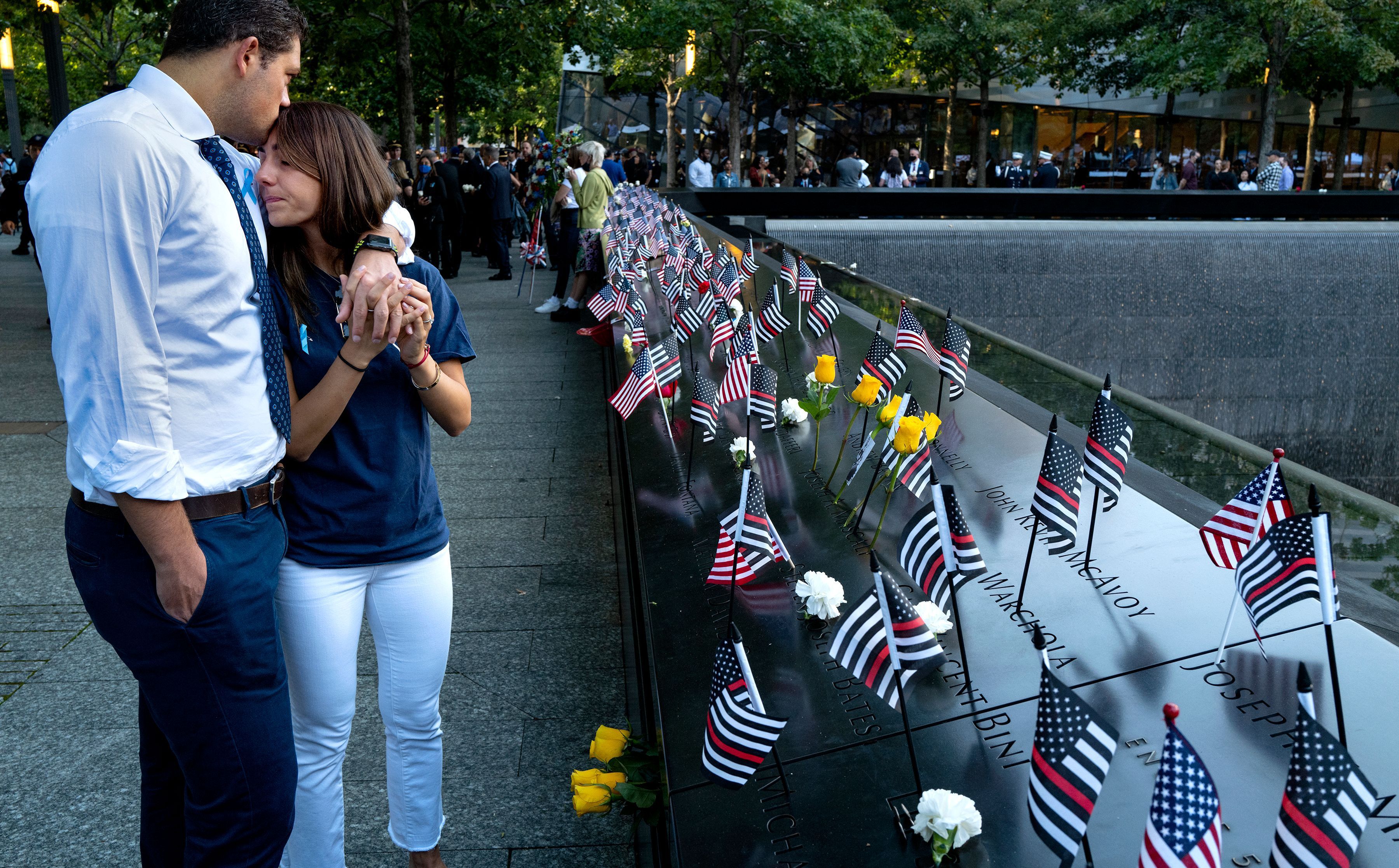 Katie Mascali is comforted by her fiance Andre Jabban as they stand near the name of her father Joseph Mascali at the National September 11 Memorial & Museum. 