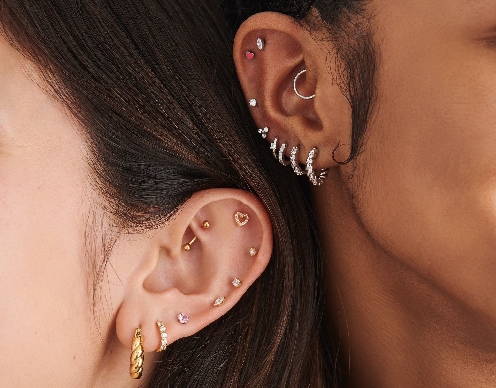 Two ears with multiple earrings in them.