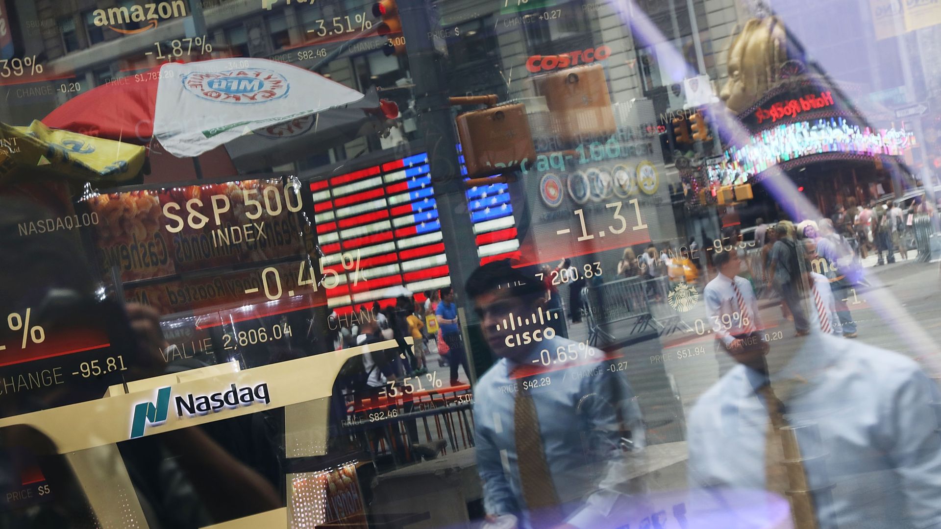 People are reflected in the window of the Nasdaq MarketSite in Times Square on July 30, 2018 in New York City