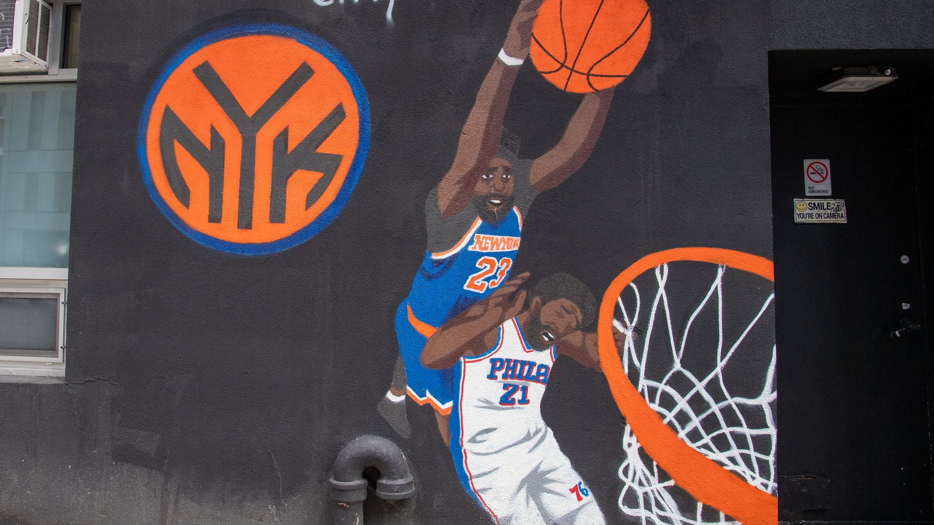 A general view of street art of New York Knicks center Mitchell Robinson dunking on Philadelphia 76ers center Joel Embiid .