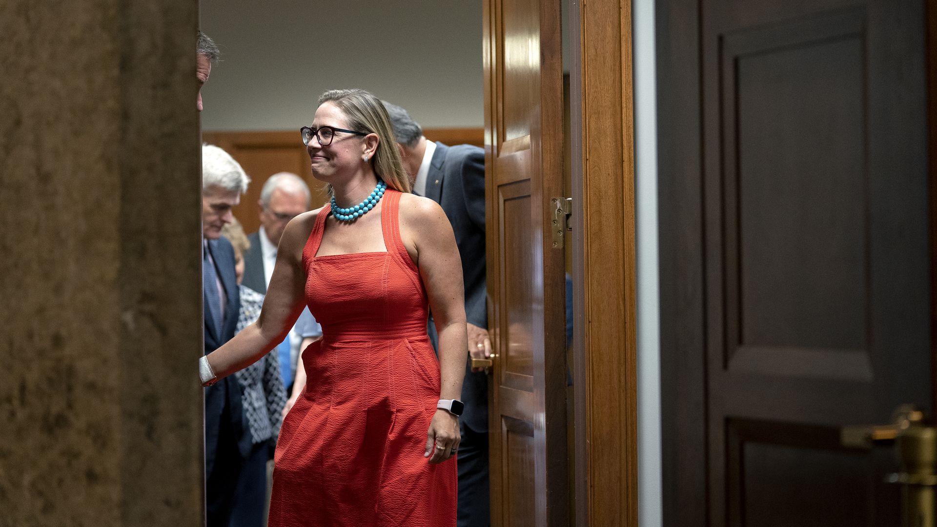 Sen. Kyrsten Sinema is seen shaking hands following a meeting of the bipartisan infrastructure negotiators.