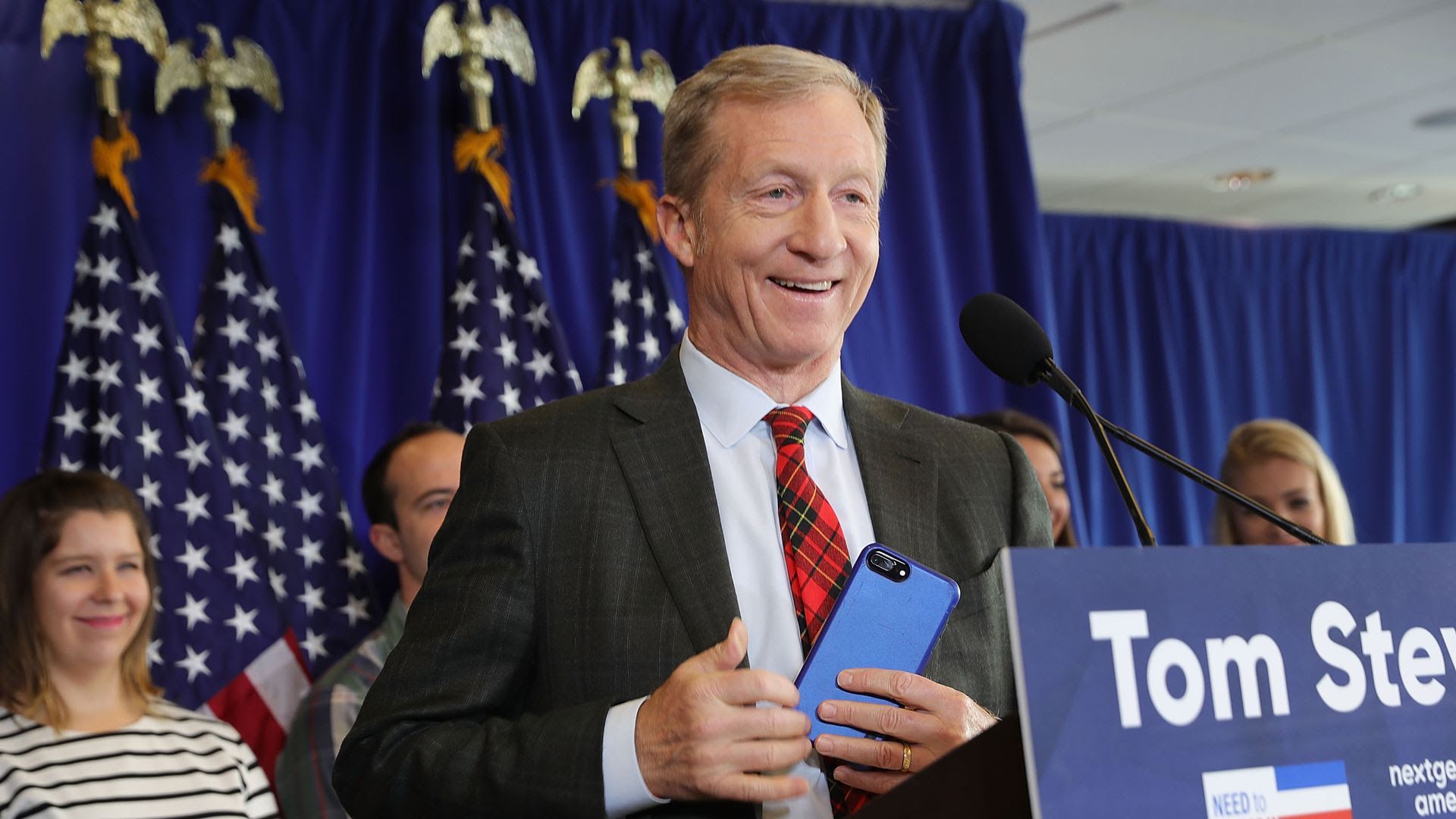 Tom Steyer smiling at a podium. 