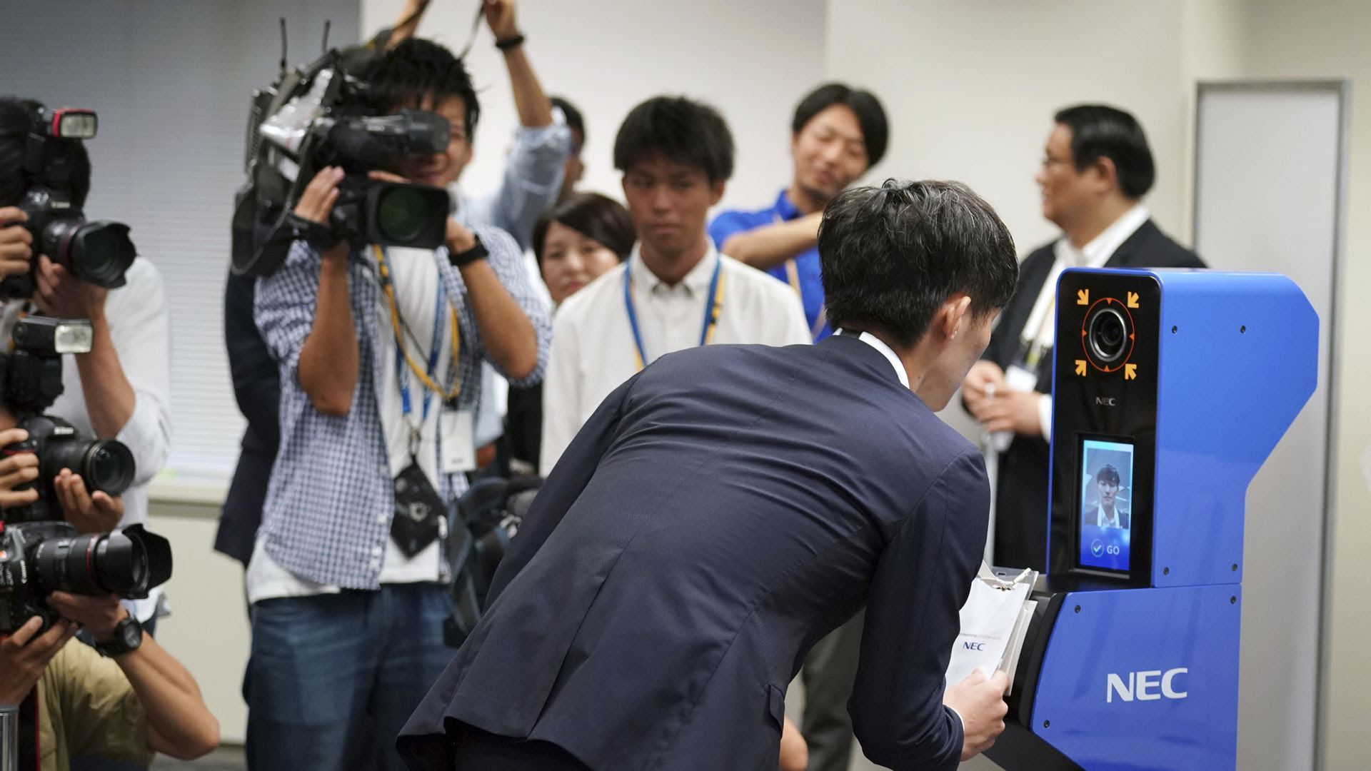 A man bends over to allow a machine to scan his face