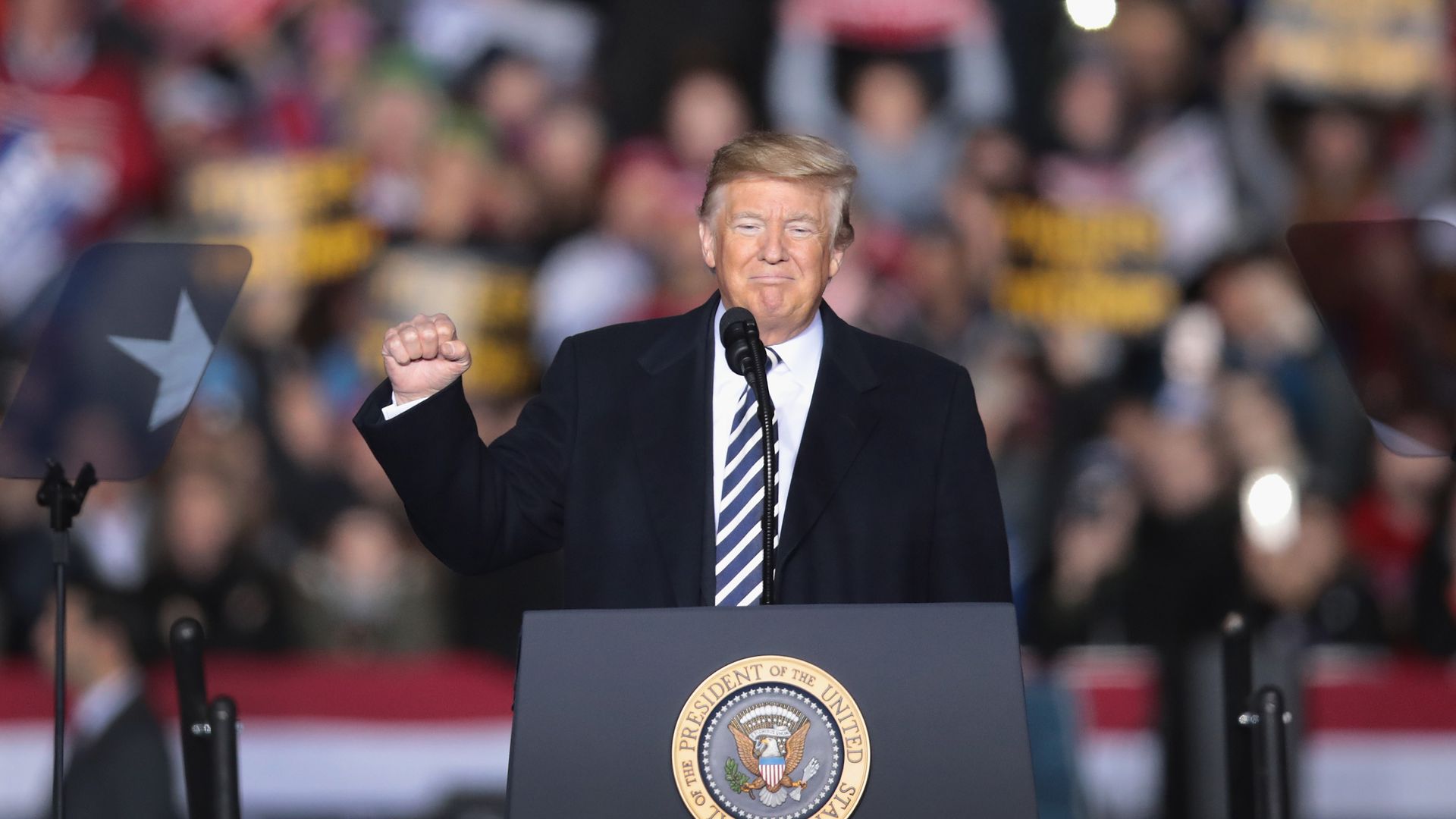 Donald trump behind the podium at a rally. 