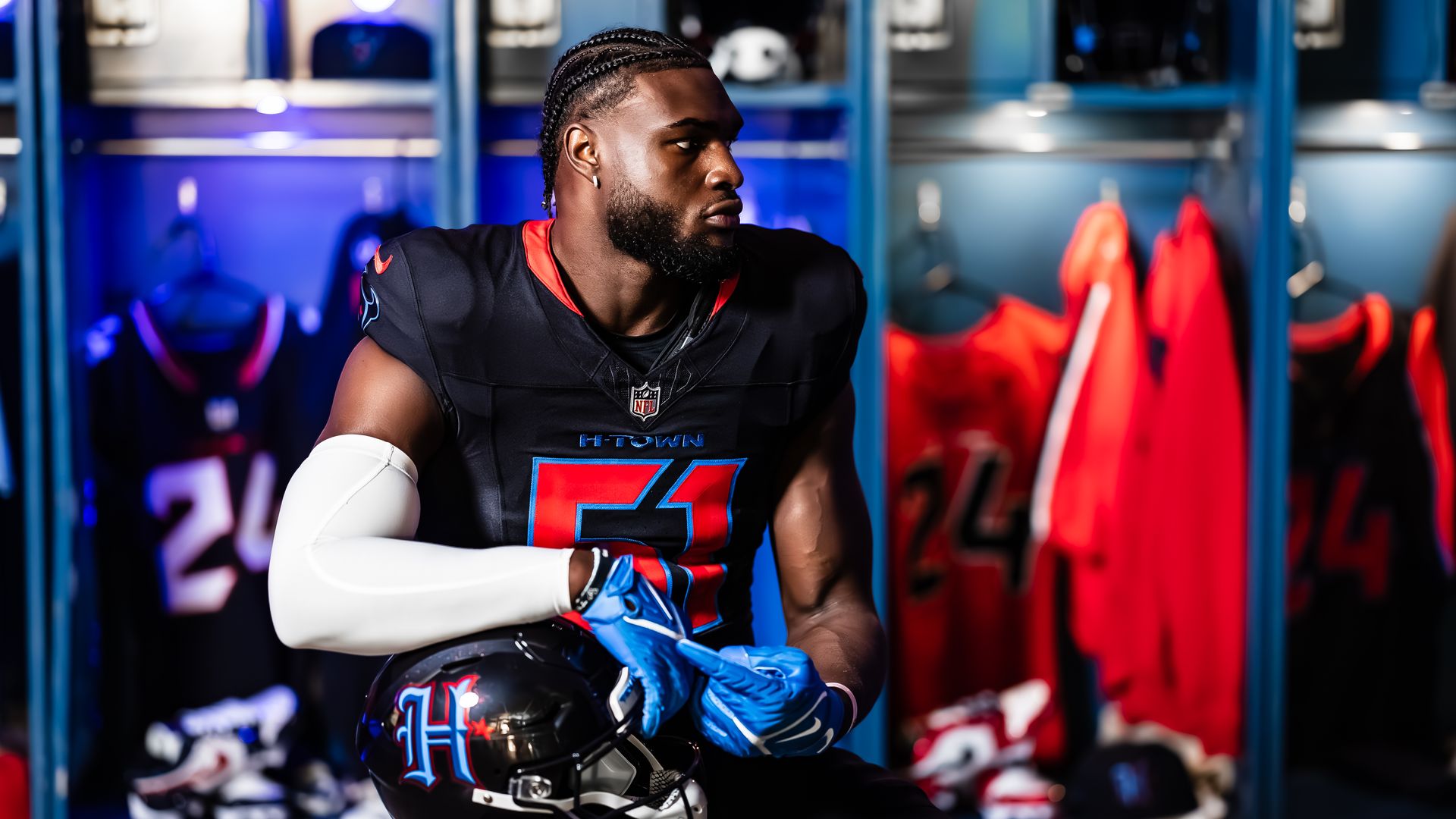Photo of a football player in a dark blue uniform in a locker room.