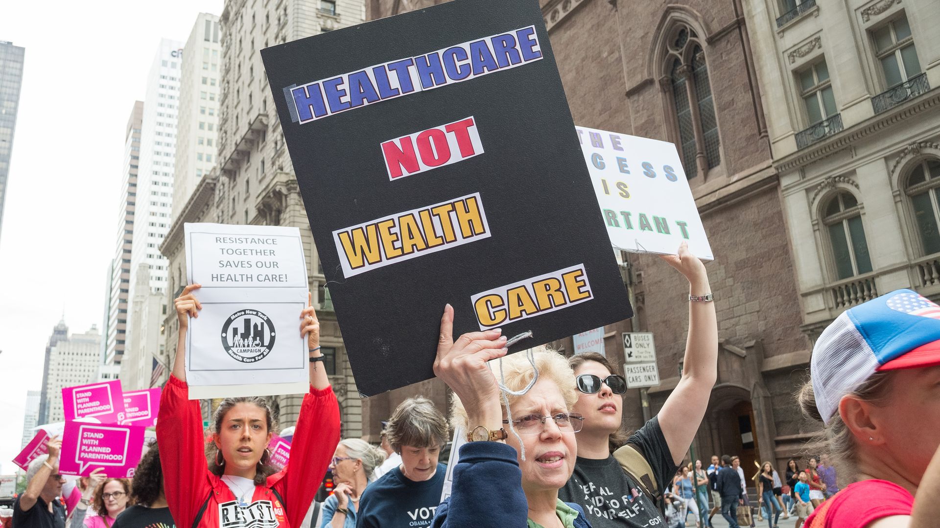 A protestor holds a sign that says, "Healthcare not wealthcare" 