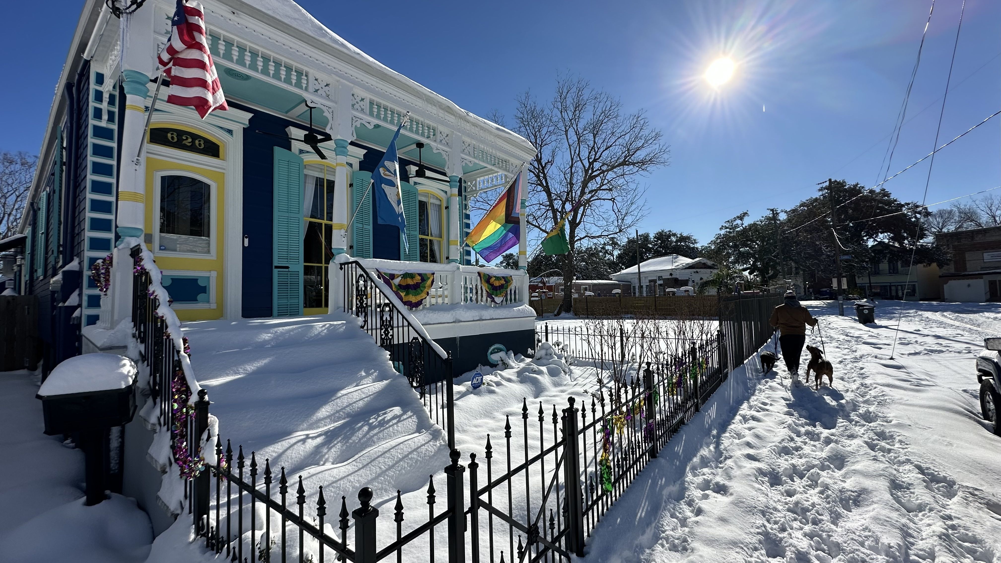 Photo shows a snowy house in the sun.