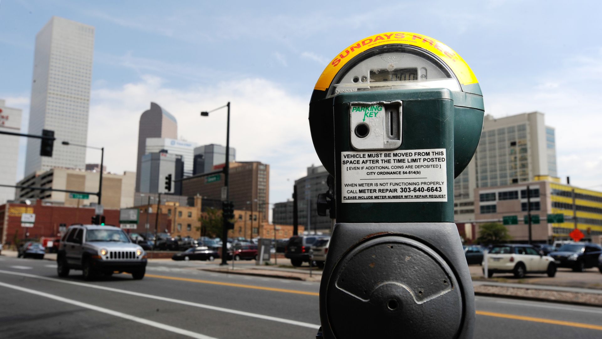 A photo of a parking meter in front of the Denver skyline