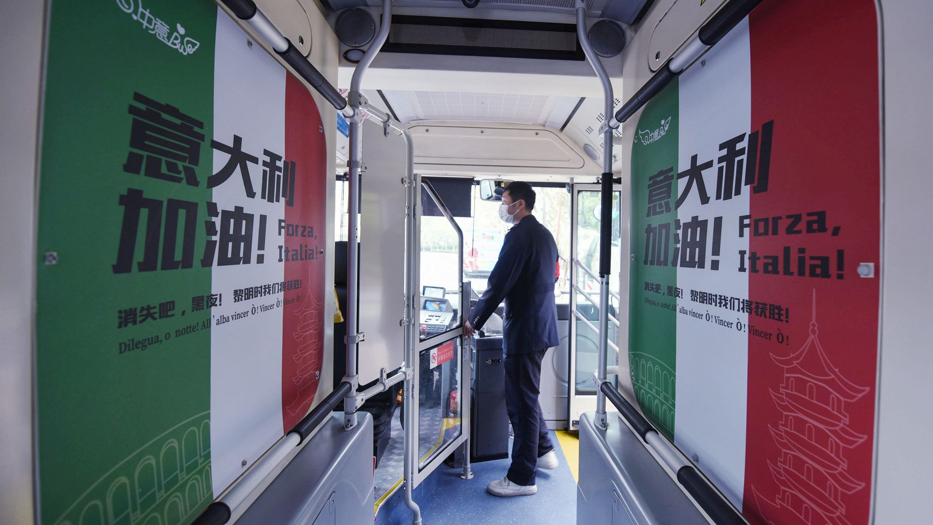  A passenger gets on a bus with a message supporting Italy in their efforts against the COVID-19 coronavirus in Hangzhou in China's eastern Zhejiang province on March 24, 2020. 
