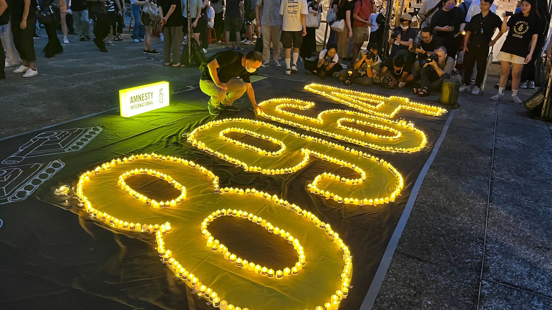 A participant places a candle on a memorial at a Tiananmen memorial at Liberty Square in Taipei, Taiwan on June 4, 2023.