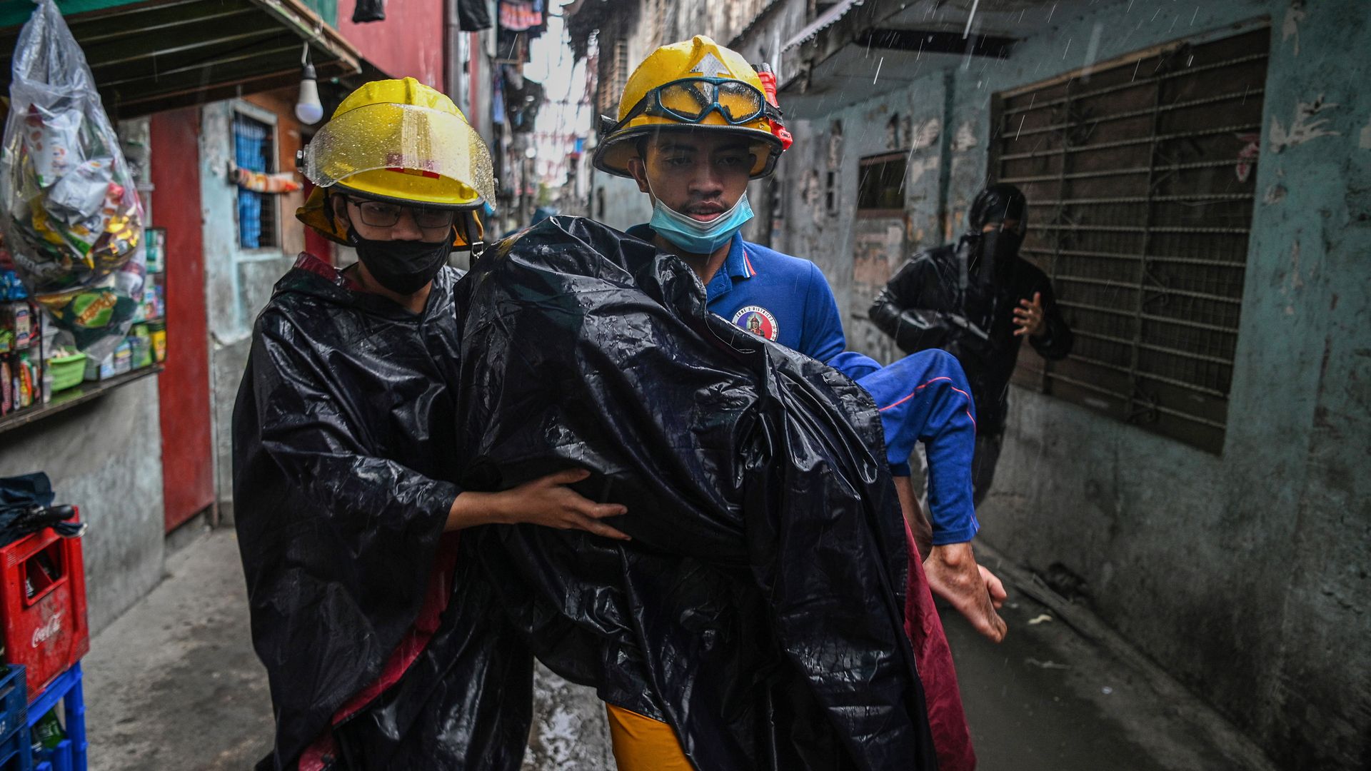  Rescue workers carry a child to a waiting vehicle during an evacuation of informal settlers living along coastal areas in Manila on November 1