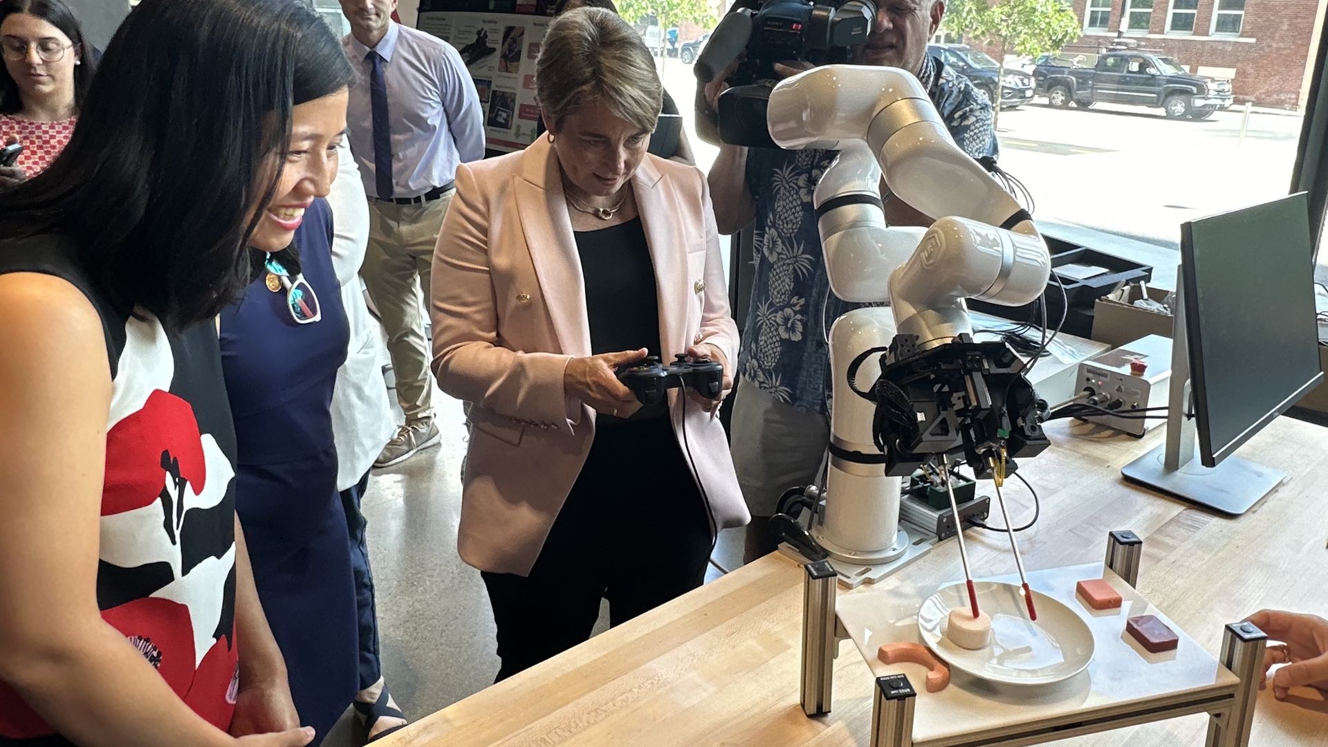 Gov. Maura Healey uses remote control to maneuver a robot.