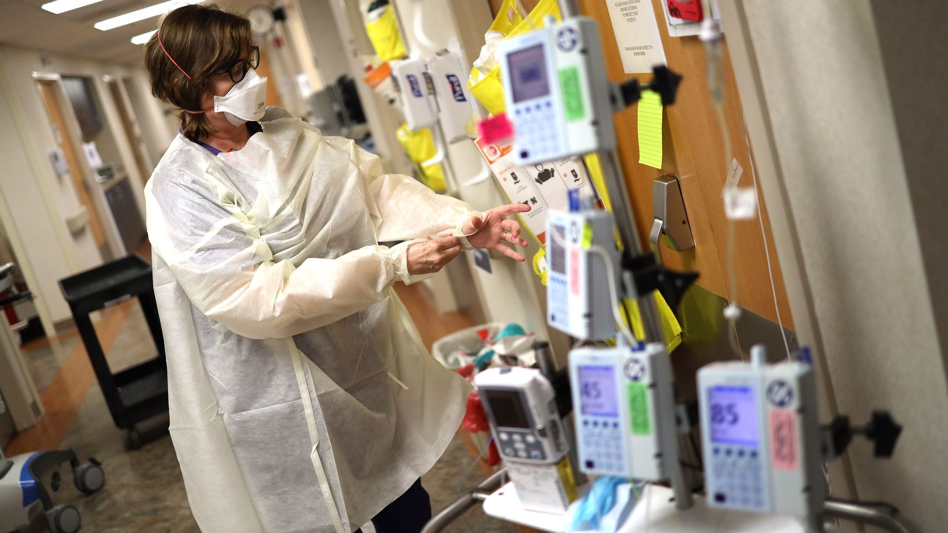 In this image, a woman wears a mask and gloves