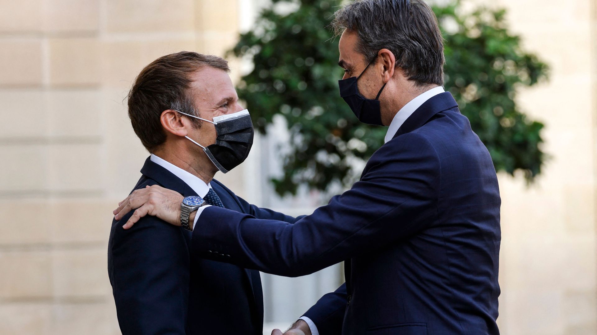 French President Emmanuel Macron (L) greets Greek Prime Minister Kyriakos Mitsotakis prior to the signing ceremony of a new defence deal at The Elysee Palace in Paris on September 28, 2021