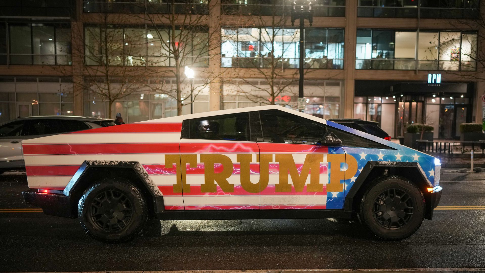 A photo of a Cybertruck painted with an American flag and the words "TRUMP."