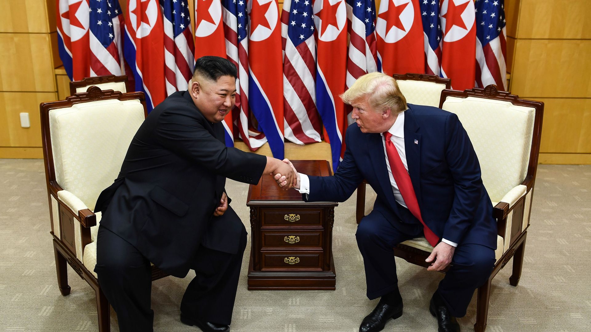 North Korea's leader Kim Jong Un (L) and US President Donald Trump shake hands during a meeting on the south side of the Military Demarcation Line.